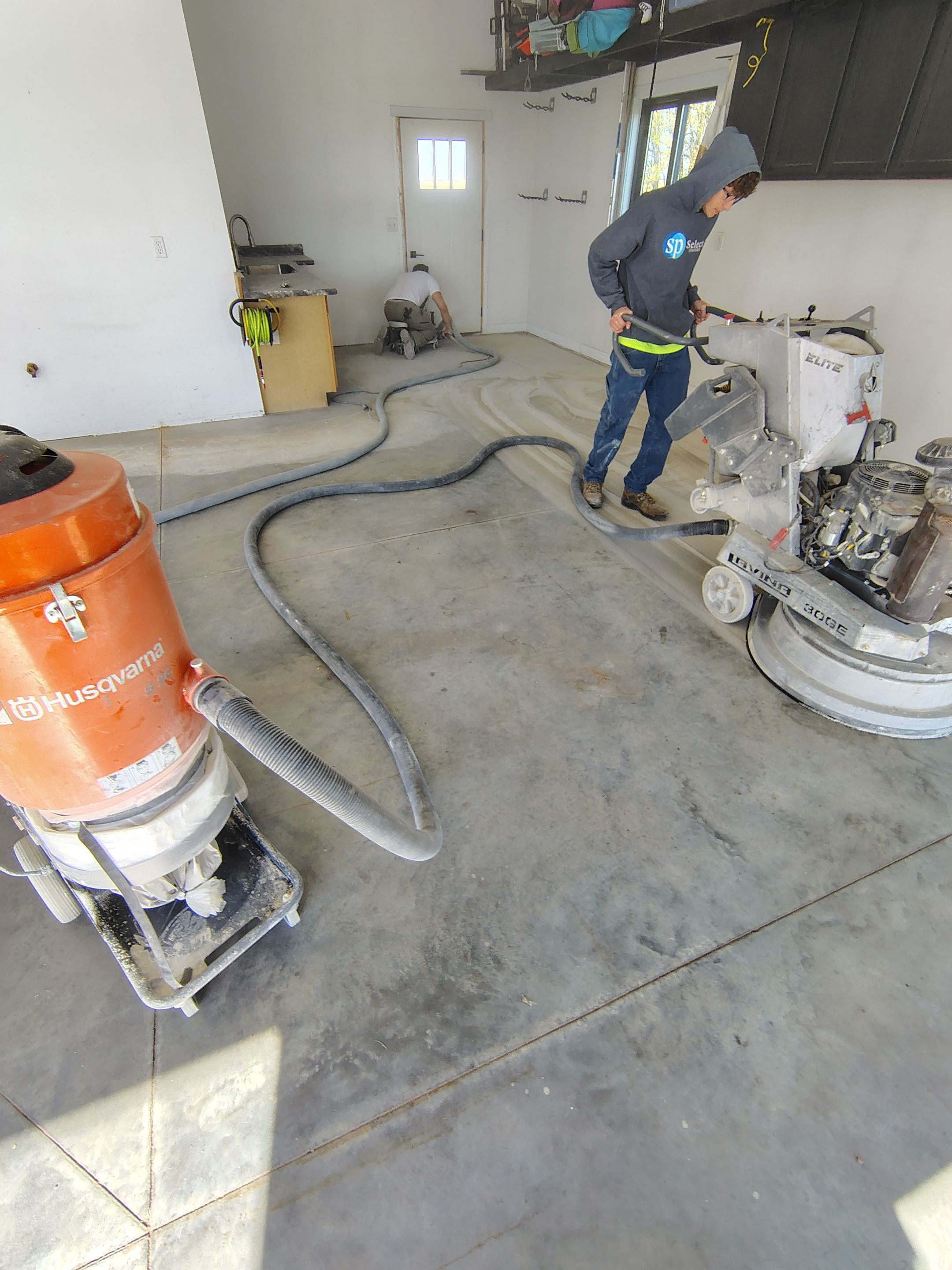 Speckled Polyaspartic Garage Floor Coating Installation in Dell Rapids by Select Painting, Coatings & Garage Cabinets