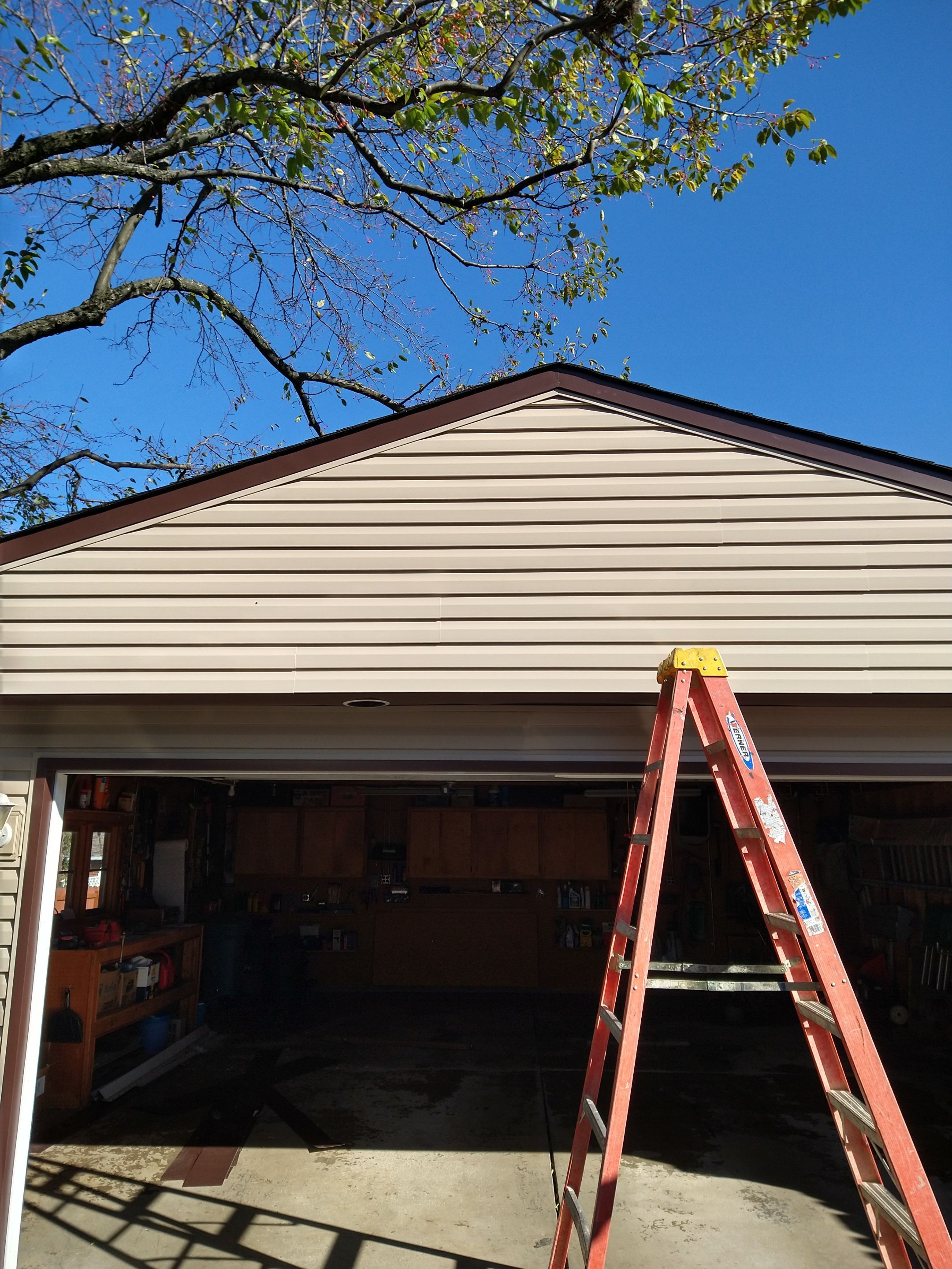 Siding Installation using Norandex woodsman dl-5 white woodgrain vinyl by Absolute Roofing and Construction