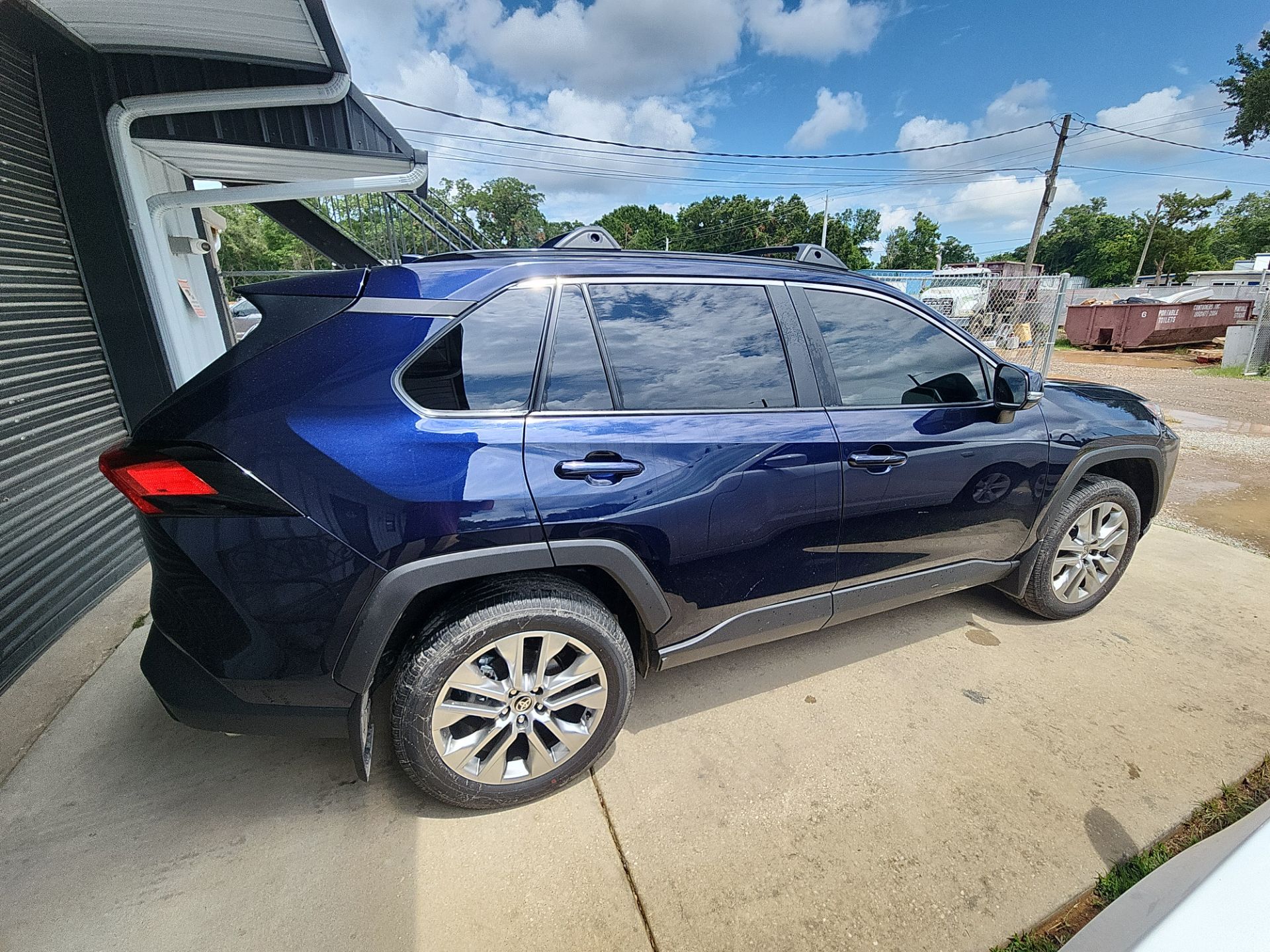 this image shows a vehicle parked outside with the windows tinted. the service being done is window tinting. it appears the tinting process is complete as the windows are darkened.