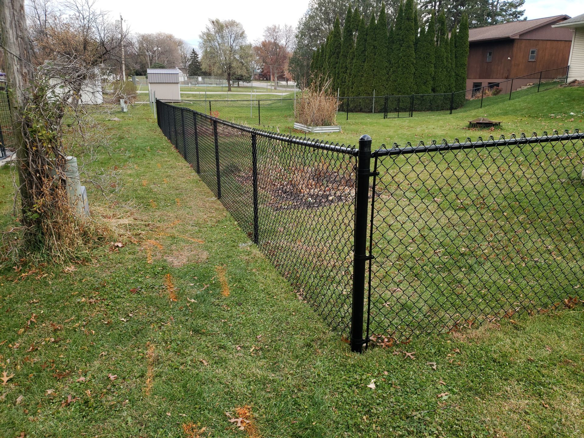 Residential Black Vinyl-Coated Chain Link Fence in Grundy Center by Perfect Picket Fence and Stain