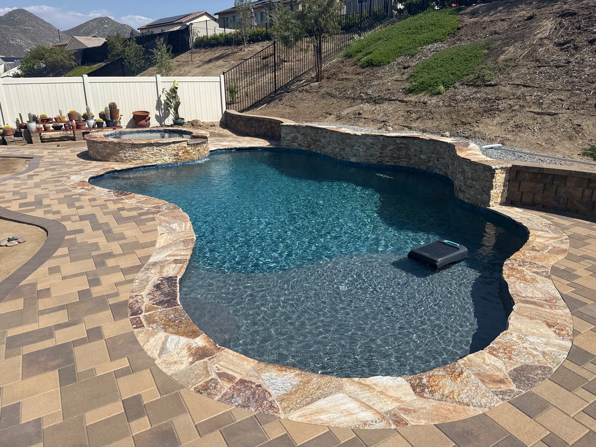 Freeform pool and spa with paver decking by Premier Pools and Spas Temecula