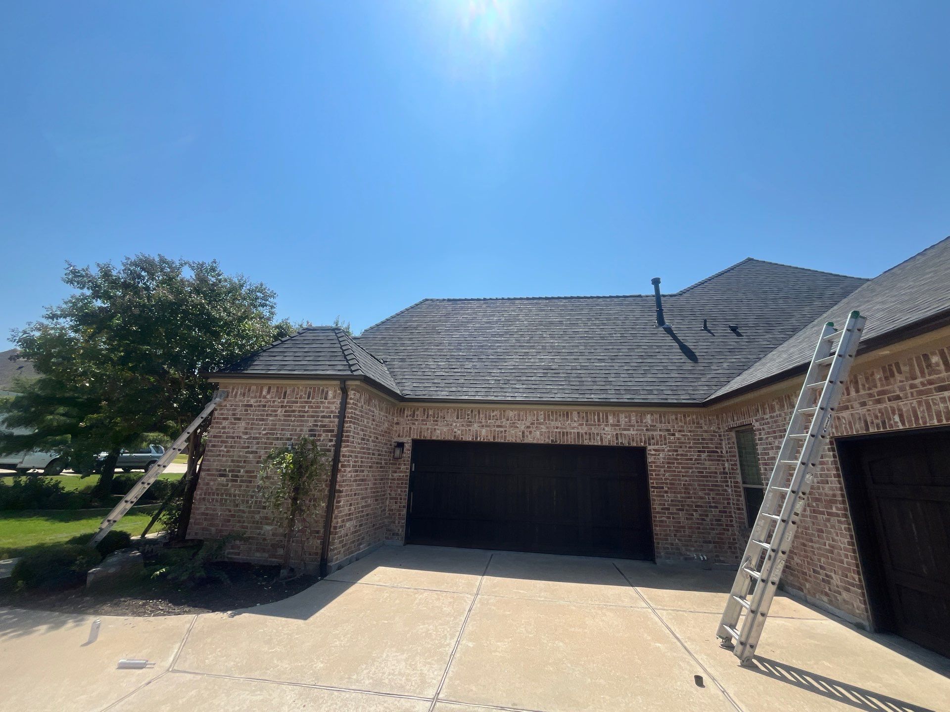 IKO Granite Black-Light Brown with dark brown sections brick house  by Tejas Roofworks + Restoration