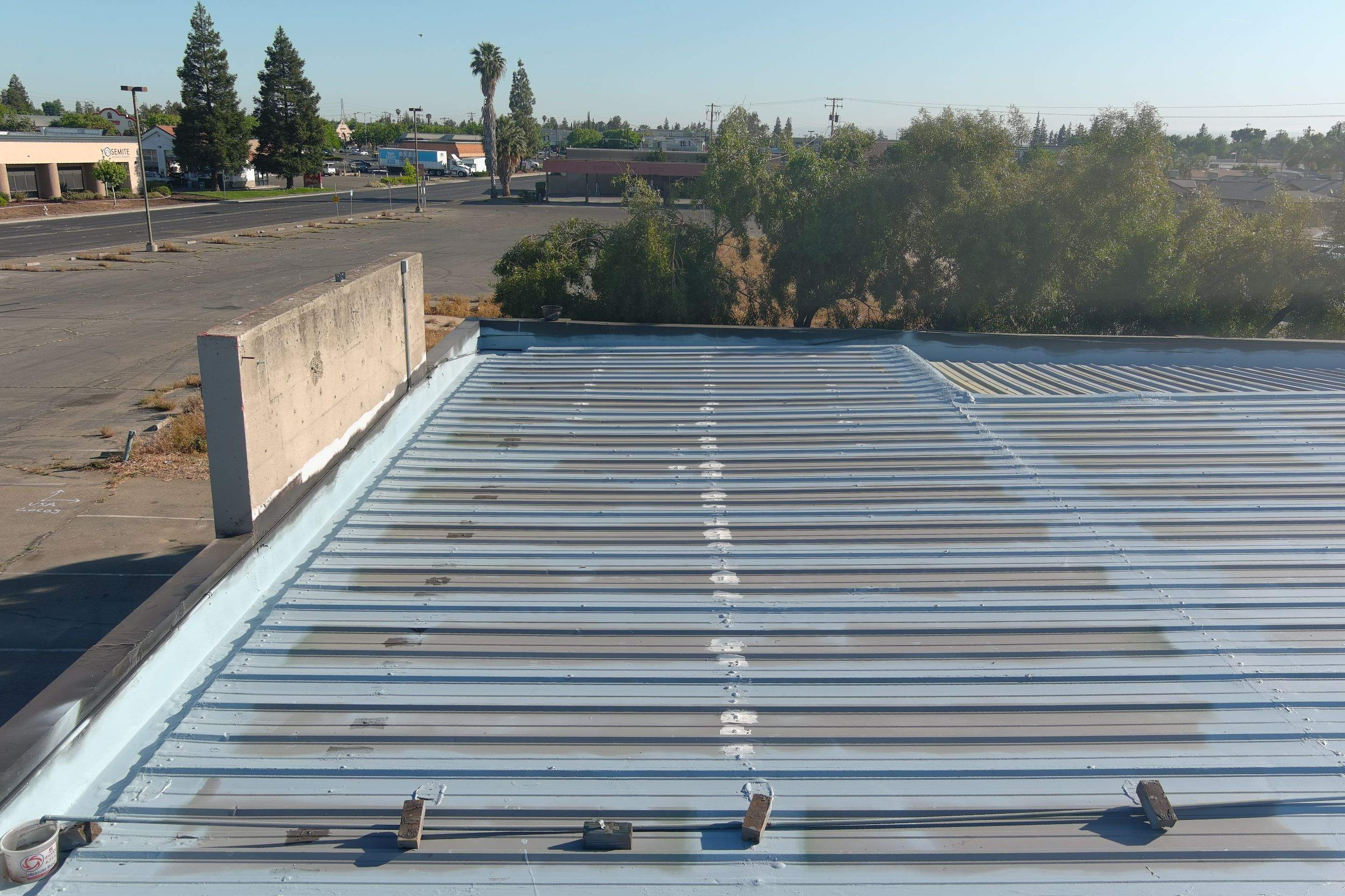 Metal roof restoration on commercial roof using Conklin Benchmark/ PUMA XL acrylic coatings over metal and foam by Straight Edge Roofing Inc