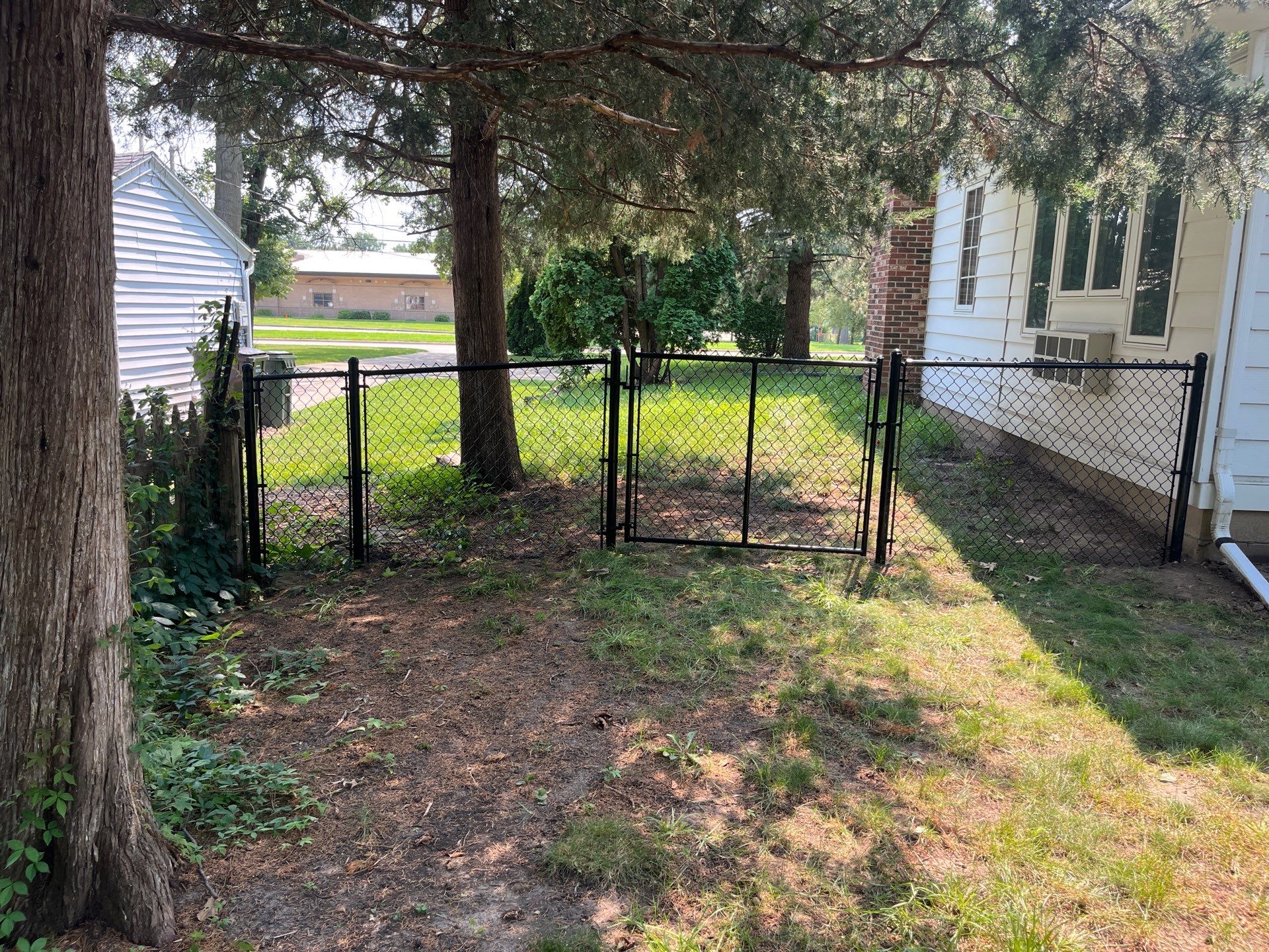Residential Black Chain Link Fence Installation in Cedar Falls by Perfect Picket Fence and Stain