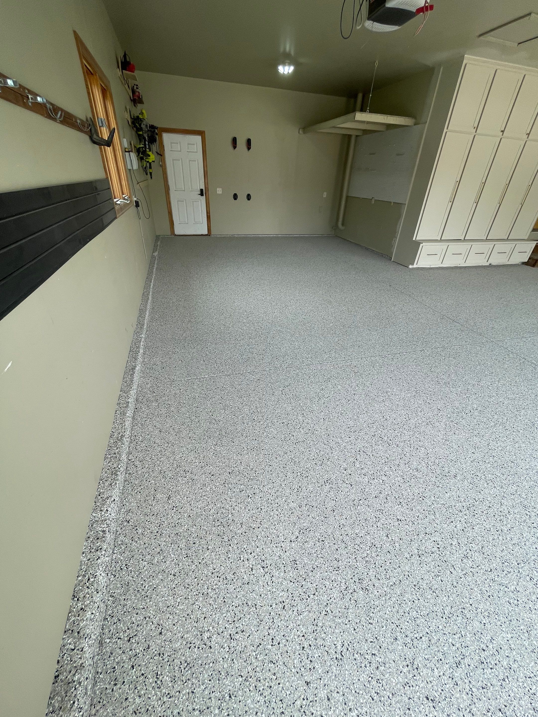 Cabin FEver Flake Garage Floor Coating Installation in Sioux Falls by Select Painting, Coatings & Garage Cabinets