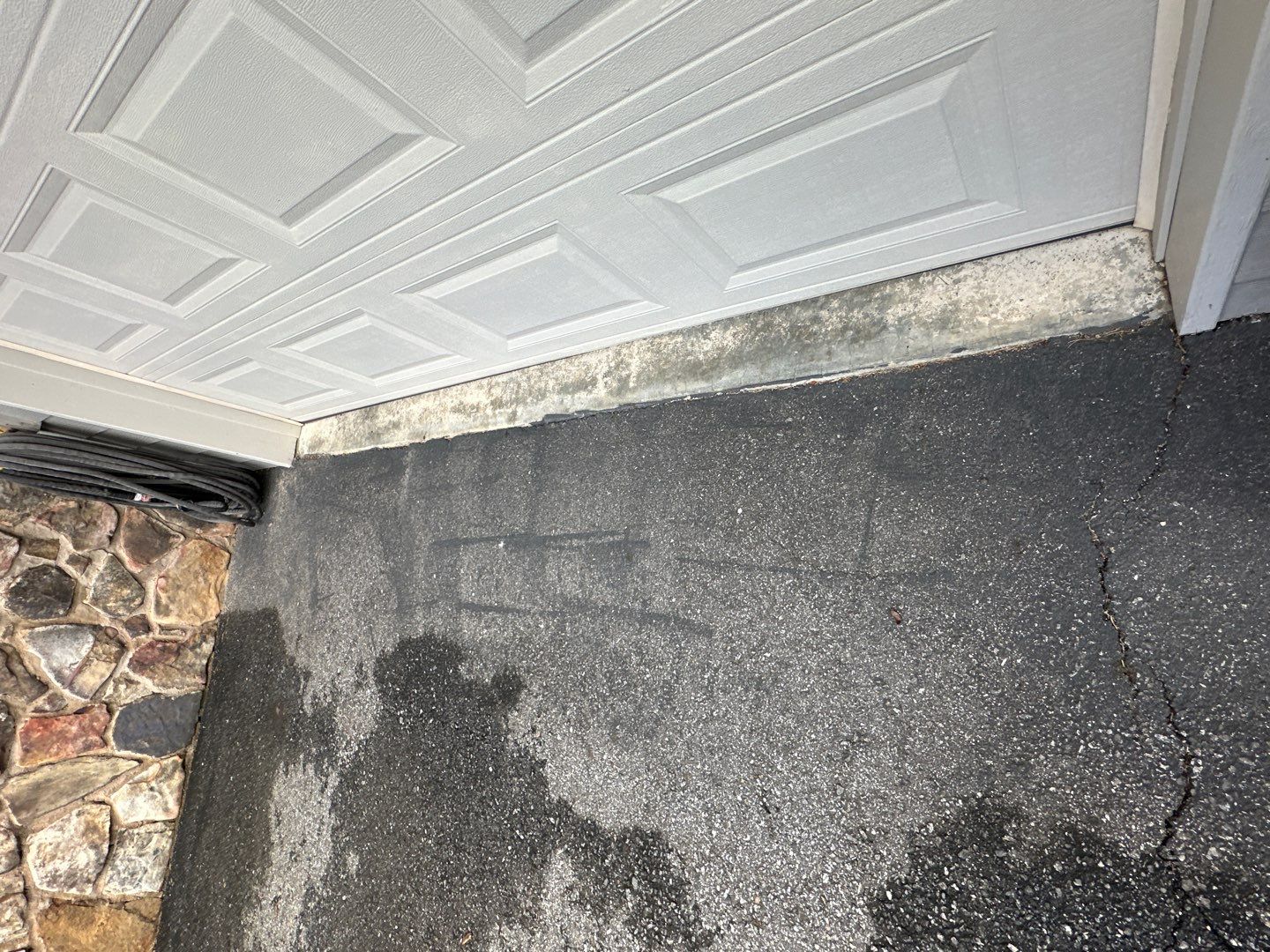 the service is cleaning the driveway and garage area removing dirt and grime from the surfaces shown