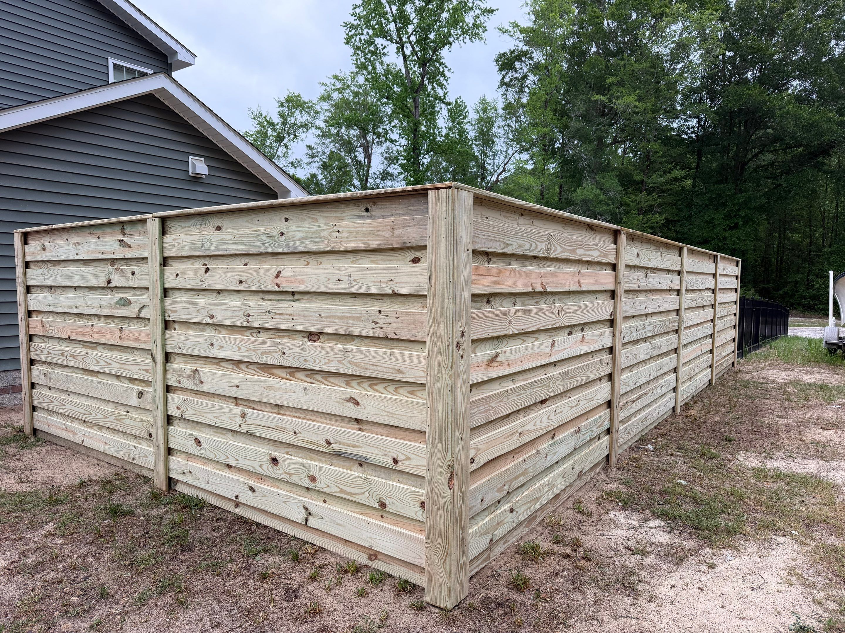 Modern Horizontal Wood Privacy Fence and Backyard Patio in Greenville by Superior Fence and Rail
