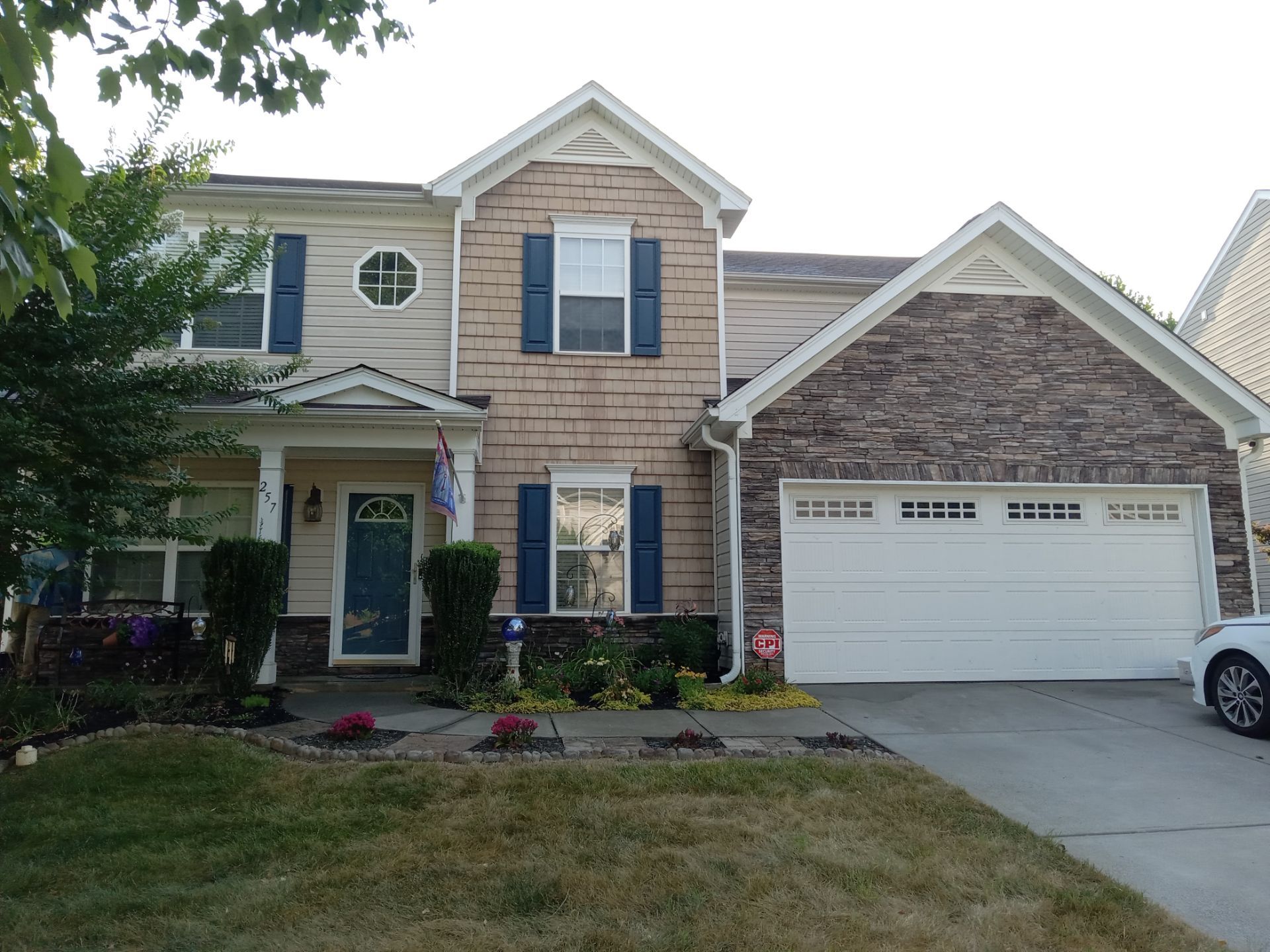 pressure washing company is cleaning house siding stone garage door walkway and driveway