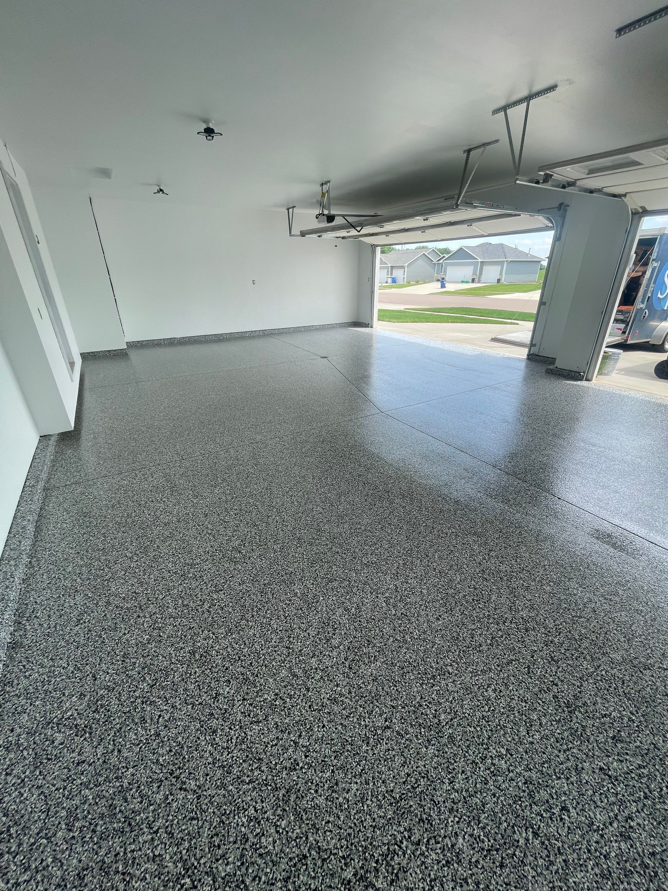 Grey Flake Epoxy Garage Floor Coating in Sioux Falls by Select Painting, Coatings & Garage Cabinets