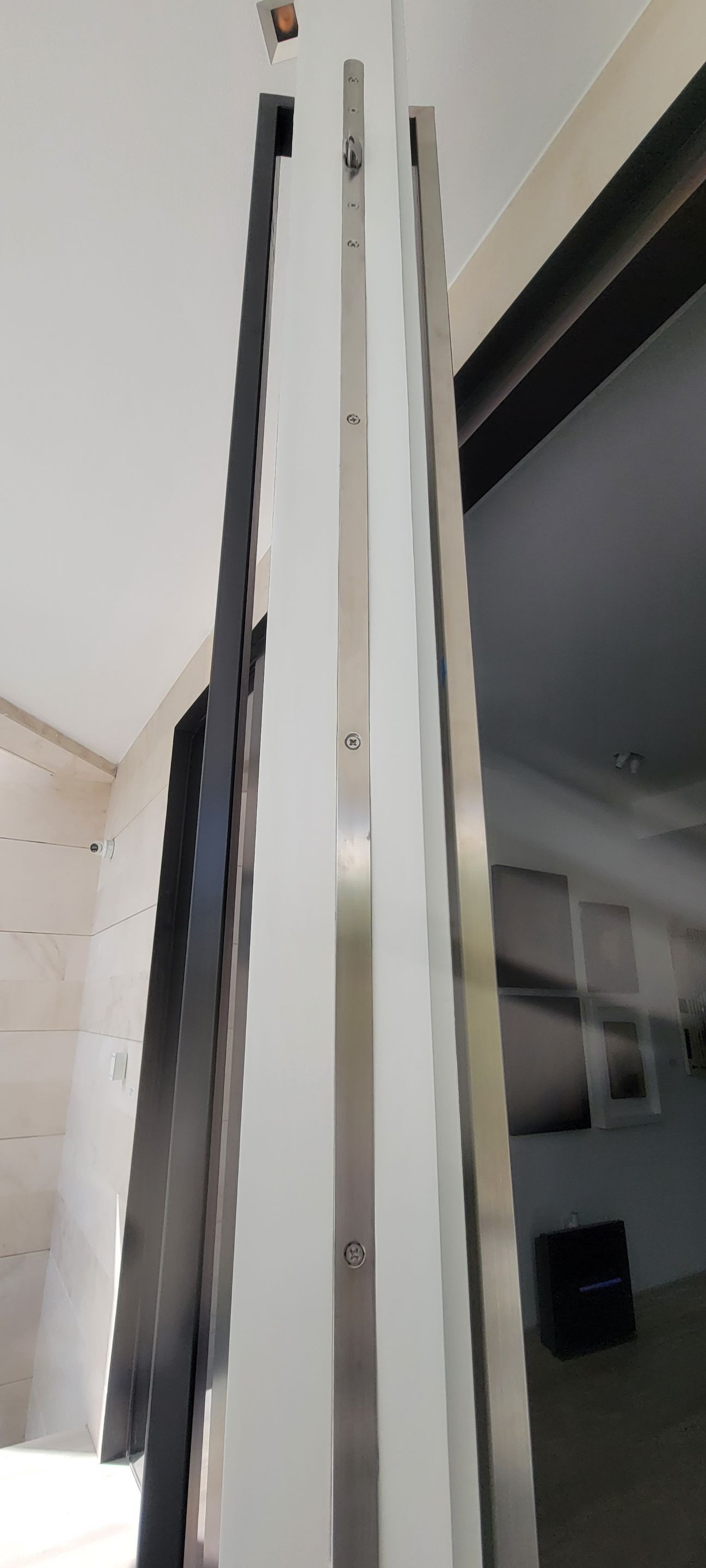 Custom Material Pivot Door installation by Impact Precious Wood Inc.