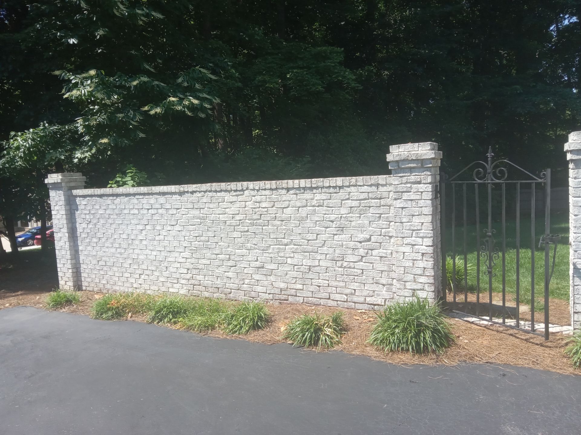 pressure washing stone wall and gate posts removing dirt moss and stains restoring original appearance