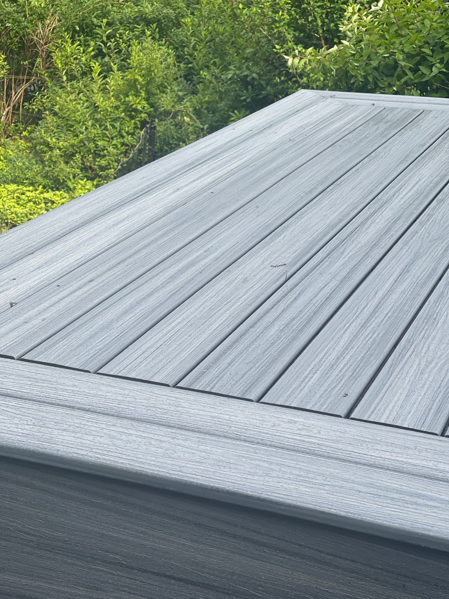 Raised Gray Composite Deck and Staircase Construction in Pocono Summit, PA by Herts Roofing & Construction