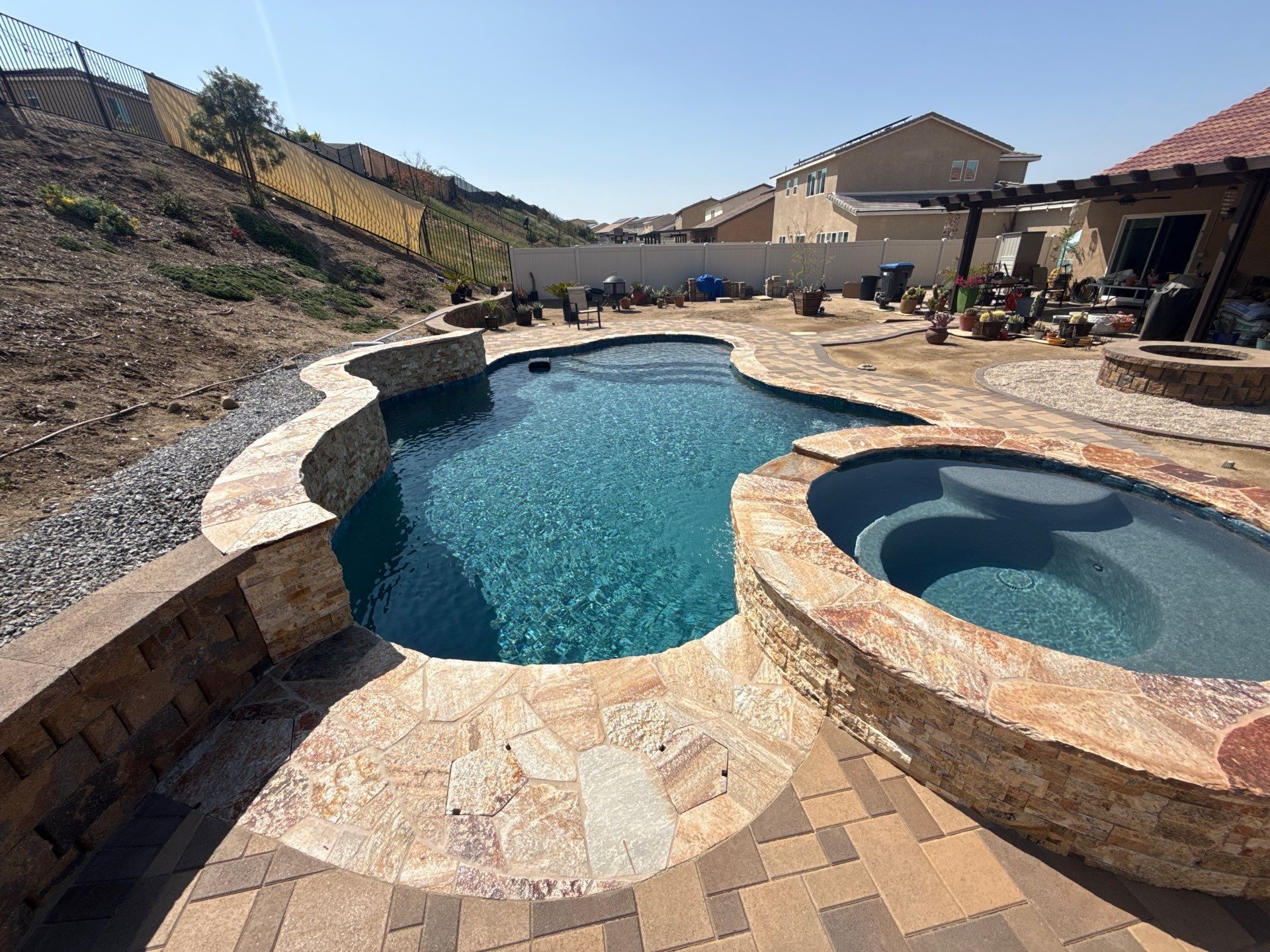 Freeform pool and spa with paver decking by Premier Pools and Spas Temecula
