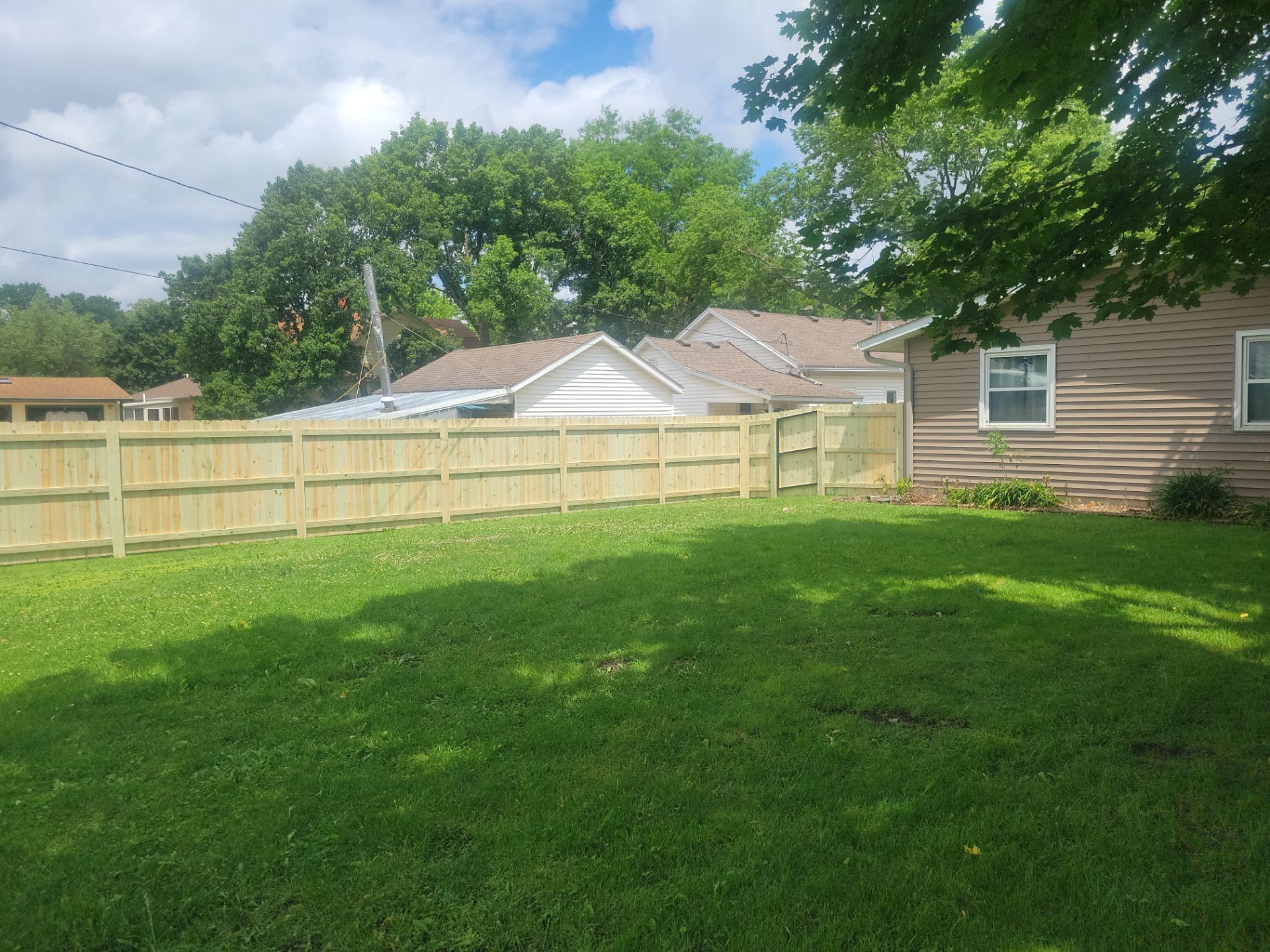 Pressure-Treated Wood Privacy Fence Installation in Charles City by Perfect Picket Fence and Stain