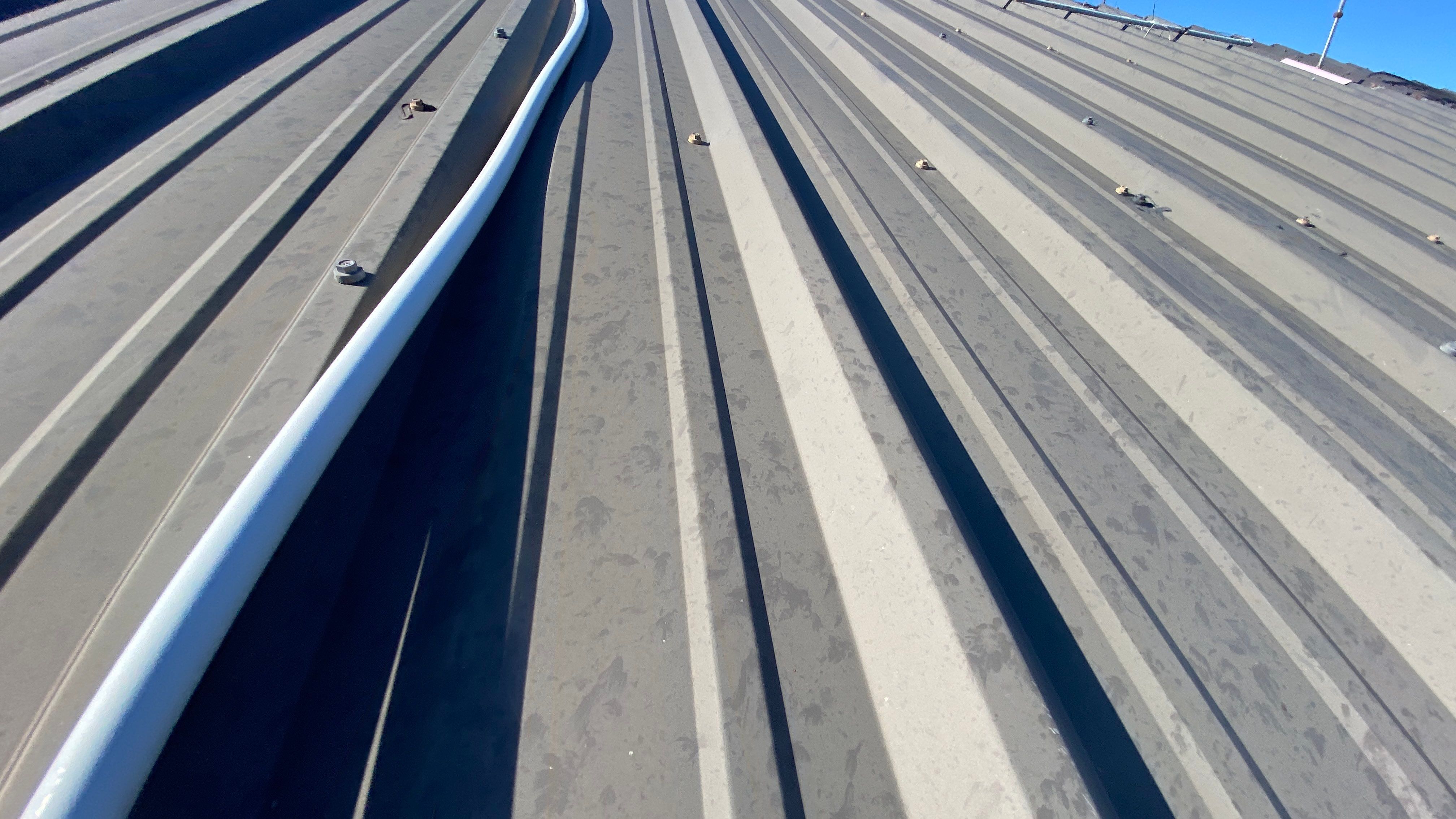 Commercial Roofing Installation using 24 GA 2" Seam Metal Retrofin - Buckskin by Action Exteriors Austin