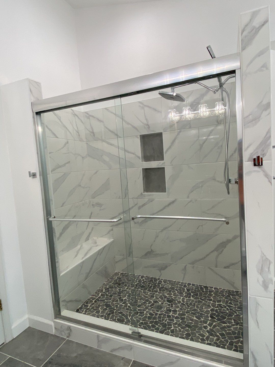 Bathroom Remodel using porcelain tiles , wood make vanetys , mirross , bathroom accessories  by Jesus Master Handyman LLC 
