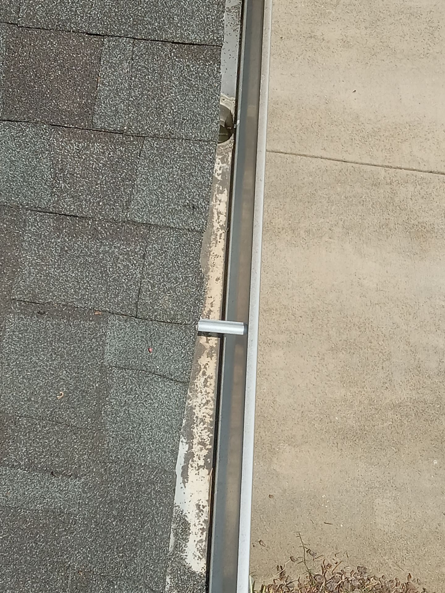 cleaning gutter and roof edge removing dirt algae and debris with high pressure water