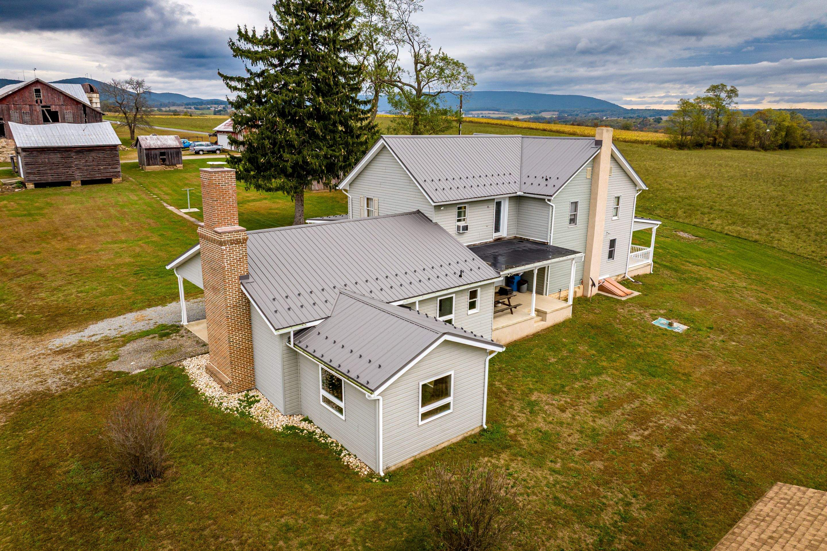 Classic Farmhouse With Textured Charcoal Metal Roof by Esh Builders