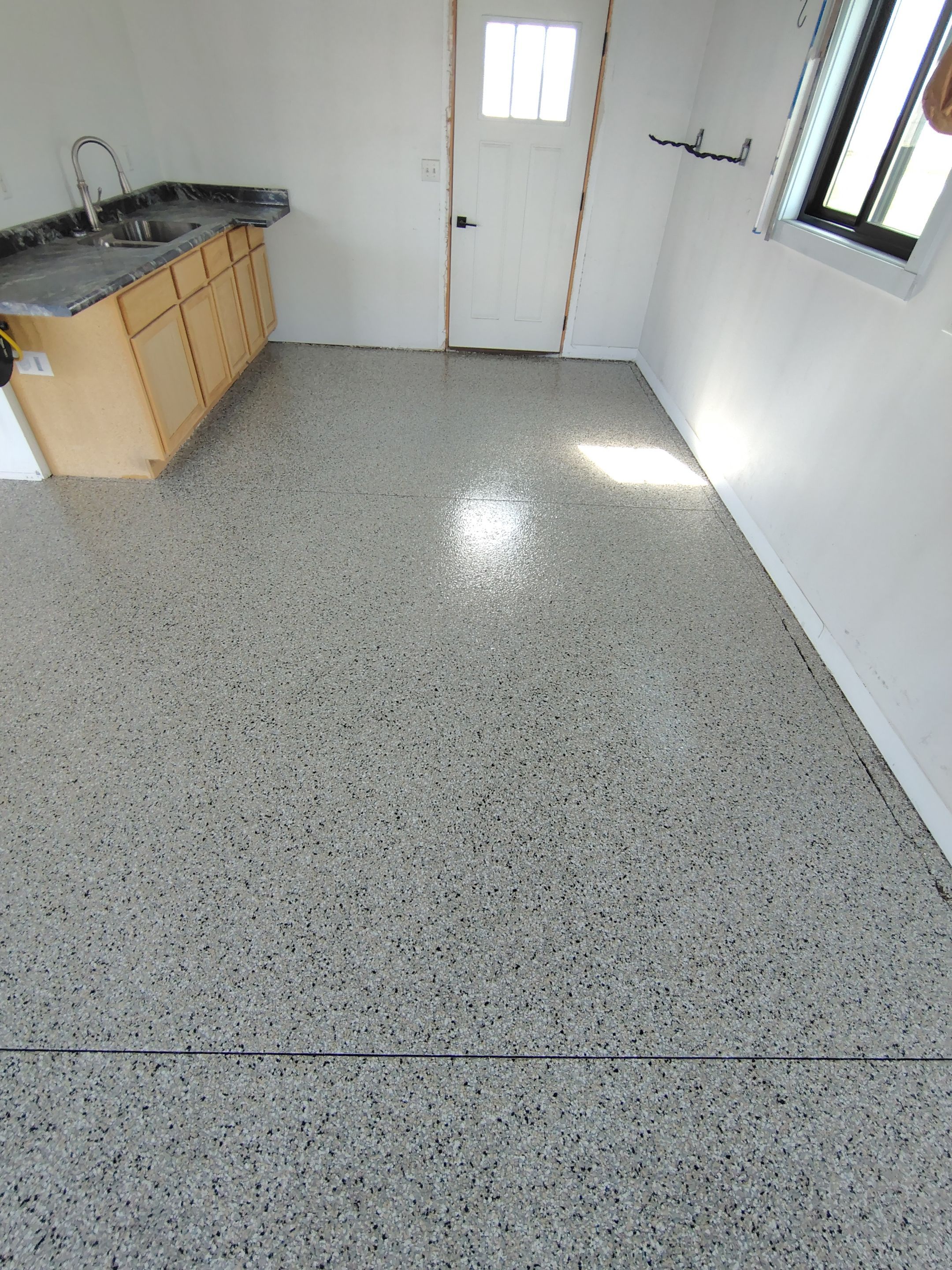 Speckled Polyaspartic Garage Floor Coating Installation in Dell Rapids by Select Painting, Coatings & Garage Cabinets