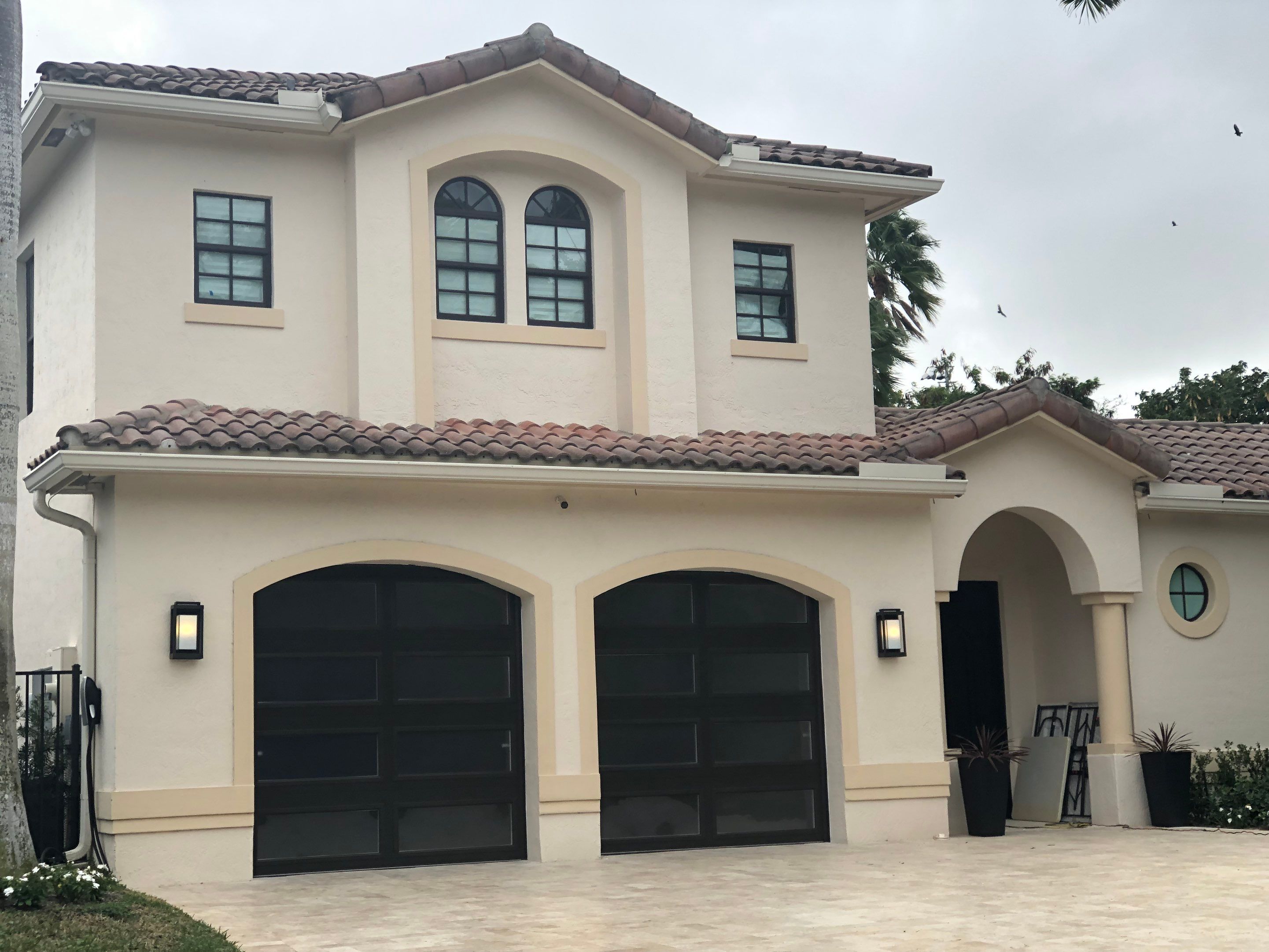 Modern Bronze Garage Door Installation With Frosted Glass in Boca Raton by The Door Doctor of South Florida, Inc.