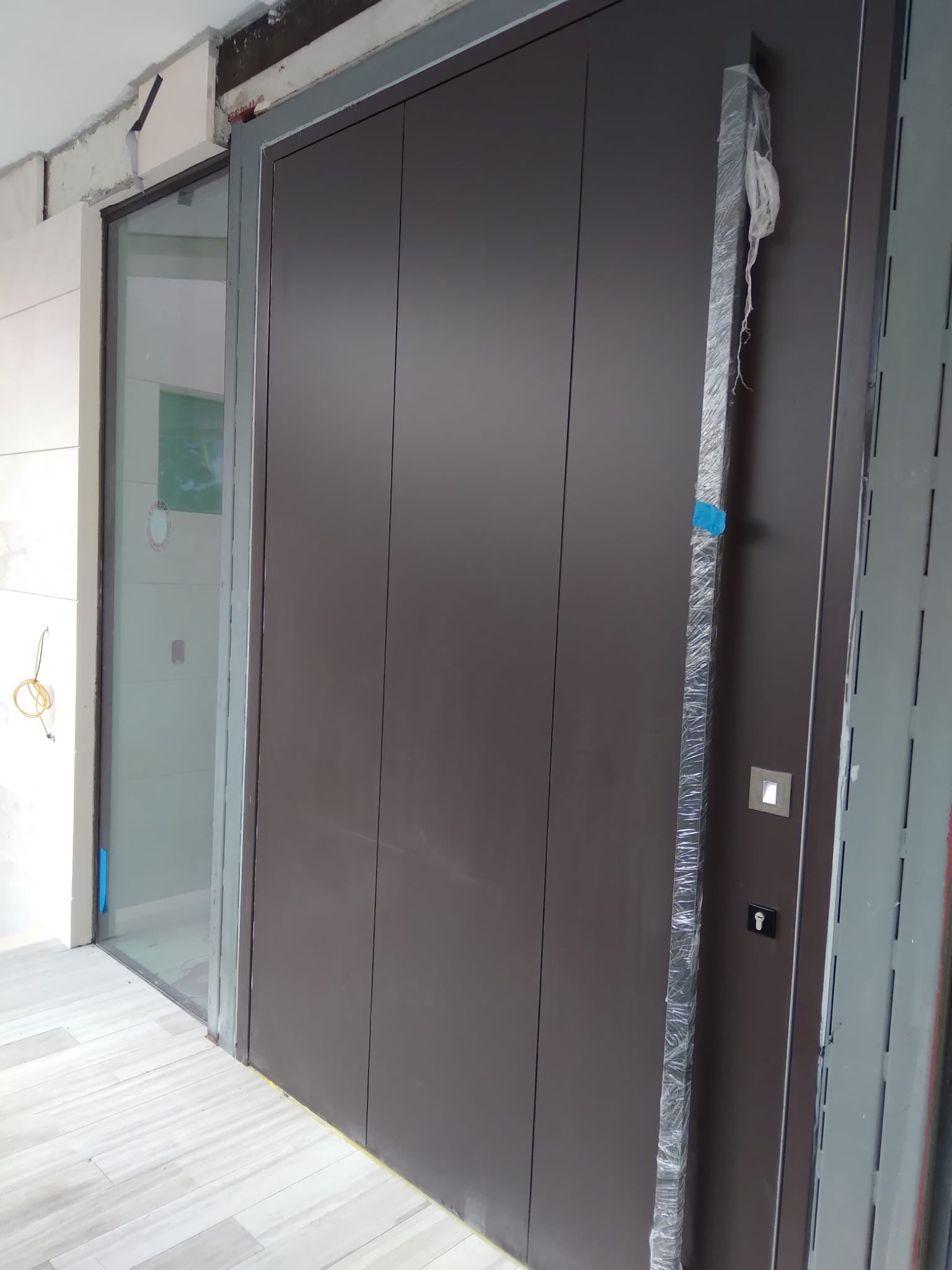 Custom Material Pivot Door installation by Impact Precious Wood Inc.