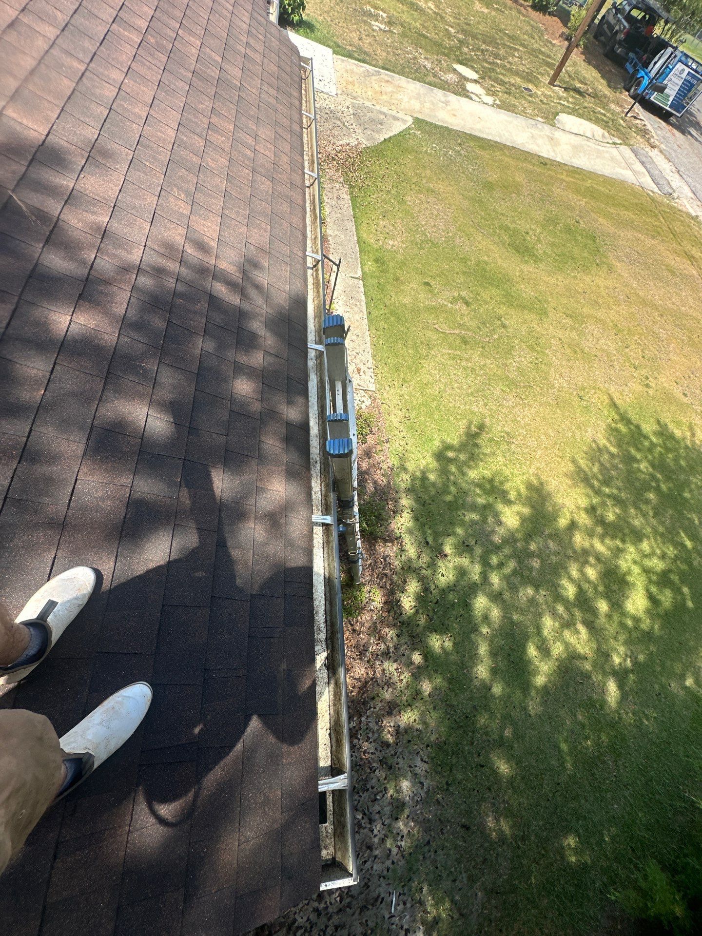 gutter cleaning is being done based on the debris and ladder setup along the gutter area