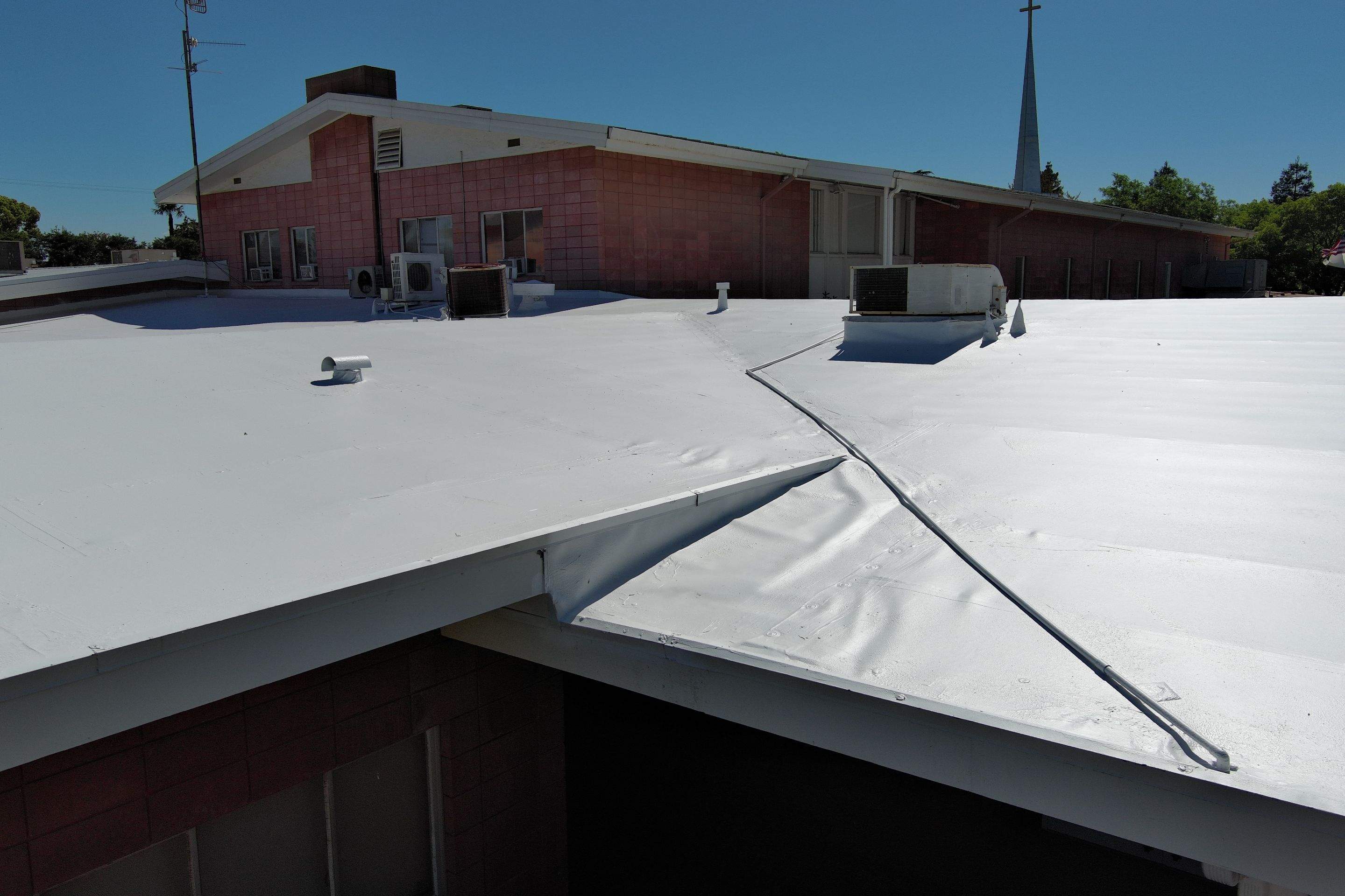 Single-ply restoration system using Benchmark/PUMA XL coatings over TPO single-ply roofing by Straight Edge Roofing Inc