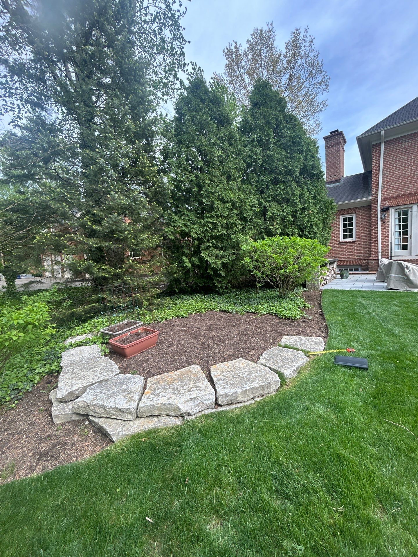 Small New Albany Synthetic Turf Putting Green with Natural Stone Border by Southwest Greens Midwest