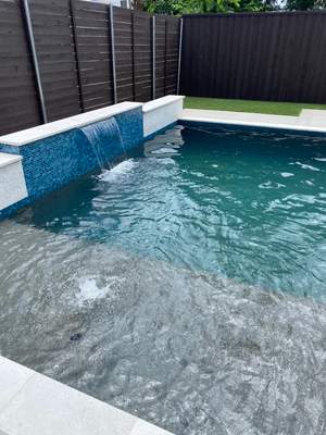 Modern Pool with Raised Glass-Tile Spa