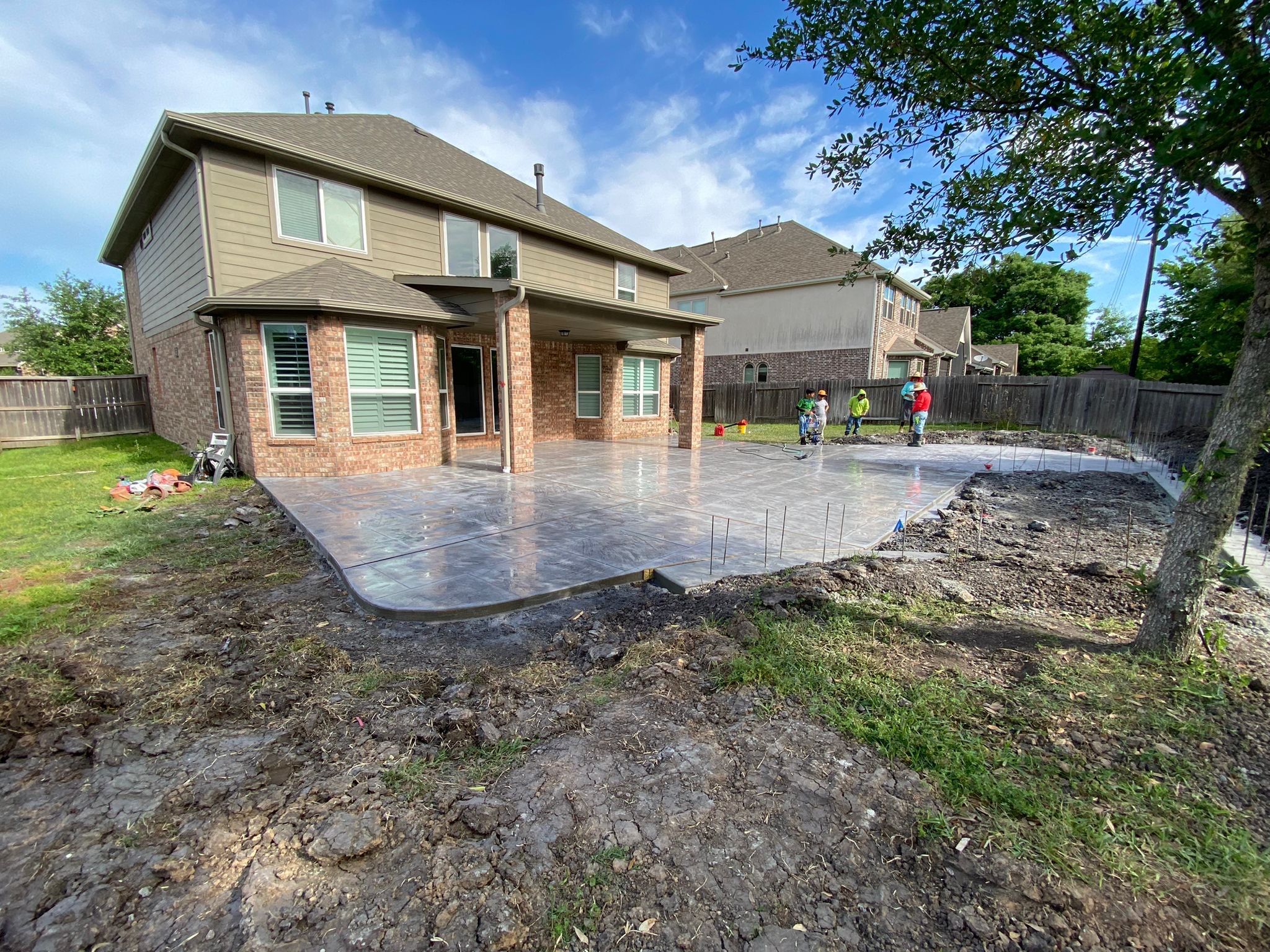 Major Transformation Project: Retaining Wall, Patio, and Drainage for Mr. & Mrs. Veerman! 🤩🛠️ We recently completed a comprehensive, custom project for Mr. & Mrs. Veerman that was all about structure, stability, and stunning outdoor design! This was a multi-phased project requiring the expertise of our Master Handcrafted Team.  Phase 1: Foundation and Water Management A successful outdoor space starts beneath the surface. We focused heavily on preparation and protection:  Demolition & Grading: We professionally removed and disposed of old dirt to achieve a level surface, ensuring the entire area was leveled and graded to enhance both appearance and functionality.  Comprehensive Drainage System: To prevent water issues and protect the new construction, we installed a complete system, connecting existing downspout gutters to channel drainage and strategically placed catch basins around the patio area.  Robust Concrete Foundation: Expert framing led to the pouring of a 4-inch deep, high PSI concrete slab to create a robust and lasting foundation for the entire retaining wall area.  Phase 2: Handcrafted Structure and Style This phase brought in our masonry and carpentry artisans to build the defining elements of the new space:  Custom Retaining Wall: Our master handcrafted team built a stunning, structural retaining wall. This involved careful framing, precise concrete work, and meticulous masonry construction with vertical supports every 3 feet for maximum stability.  Client Involvement: Mr. & Mrs. Veerman played a key role in selecting the retainer wall fascia and stone materials, ensuring the final look perfectly matched their vision.  Stamped Concrete Patio: We installed a beautiful stamped concrete patio. This decorative concrete work involved imprinting a pattern into the fresh concrete, giving them the high-end look of stone or brick with the durability of concrete.  Walk Add-On: Extended the stamped concrete to include a new, seamless walk area.  (Optional) Custom Garden Box: Constructed durable, raised garden boxes using 2"x12" boards and strong 4"x6" posts.  Phase 3: Landscaping and Finishing Touches The final details bring the entire project to life, focusing on irrigation and planting:  Sprinkler System Upgrade: To support their new landscaping, we upgraded their irrigation system by installing two new drip zones and a new control unit.  Flower Beds: Integrated new flower beds along the retaining wall and patio, ready for planting.  Decoration: Concluded the project with personalized decoration options to perfectly complement their beautiful, newly structured space.  Thinking About a Multi-Layered Outdoor Project? This project demonstrates our ability to seamlessly handle complex jobs—from heavy-duty drainage and structural construction to decorative finishes and irrigation.  The proposed timeline for this extensive project was 10 to 15 working days!  ❓ Do you have a sloping yard or drainage issues that could be solved with a functional and beautiful retaining wall? Tell us your challenge! 👇  💡 We specialize in bringing intricate outdoor visions to life! If you're looking for a team with master craftsmen for your next patio, retaining wall, or full landscape overhaul, let's talk. by Texas Urban Elements