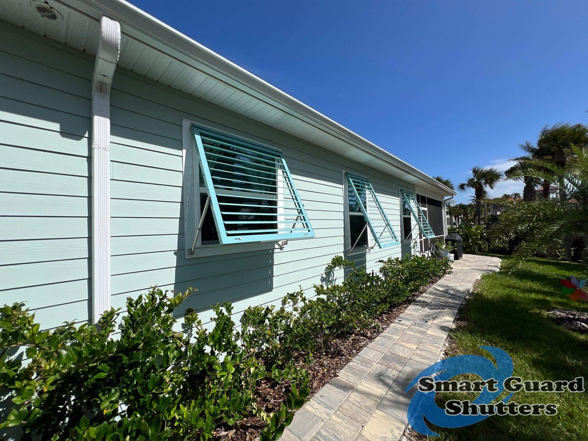 Impact Bahama Shutters in Pastel Turquoise by Smart Guard Shutters