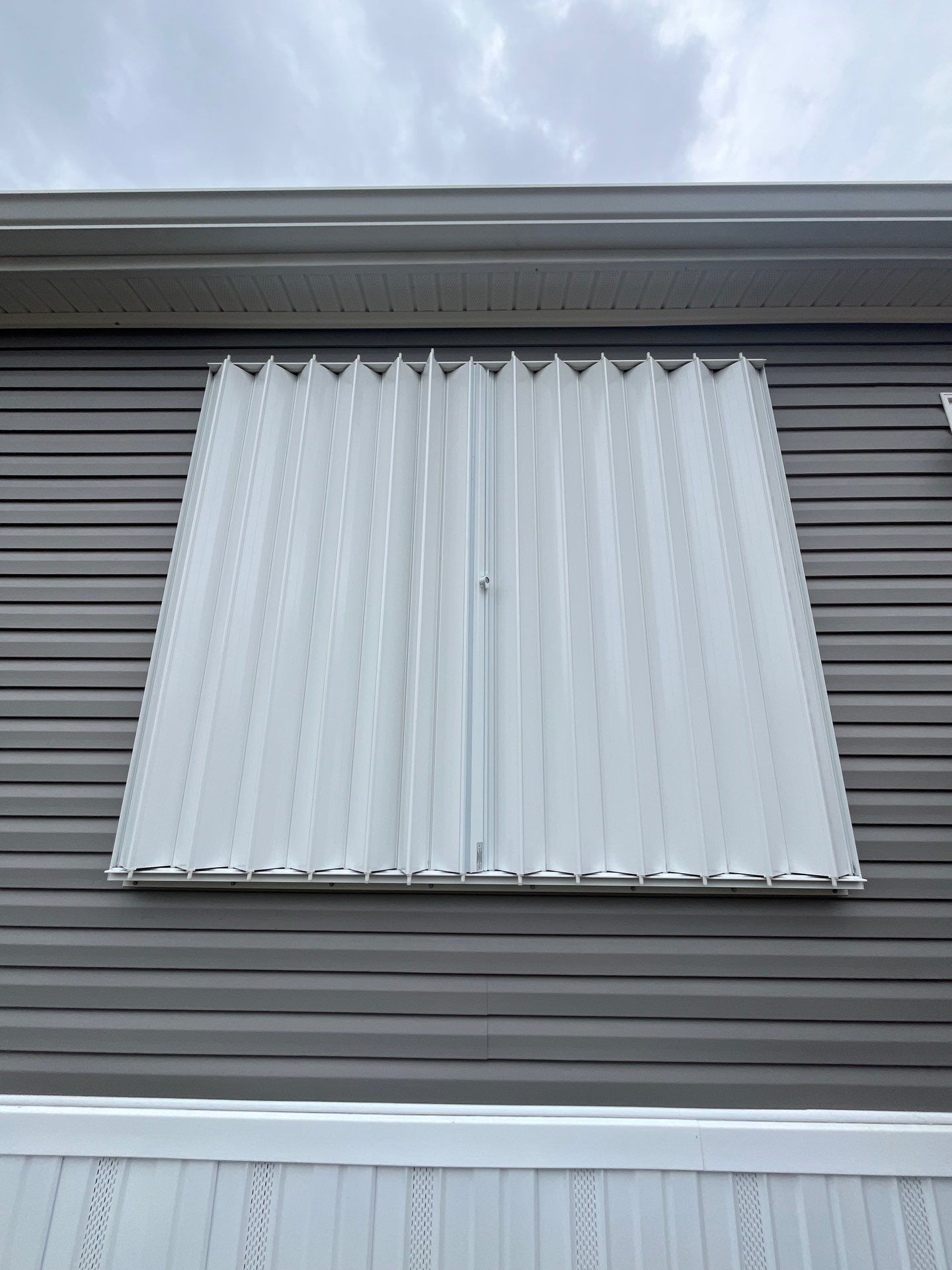 Residential Accordion Hurricane Shutter Installation in Fountain, Florida by Brannan Aluminum Inc.