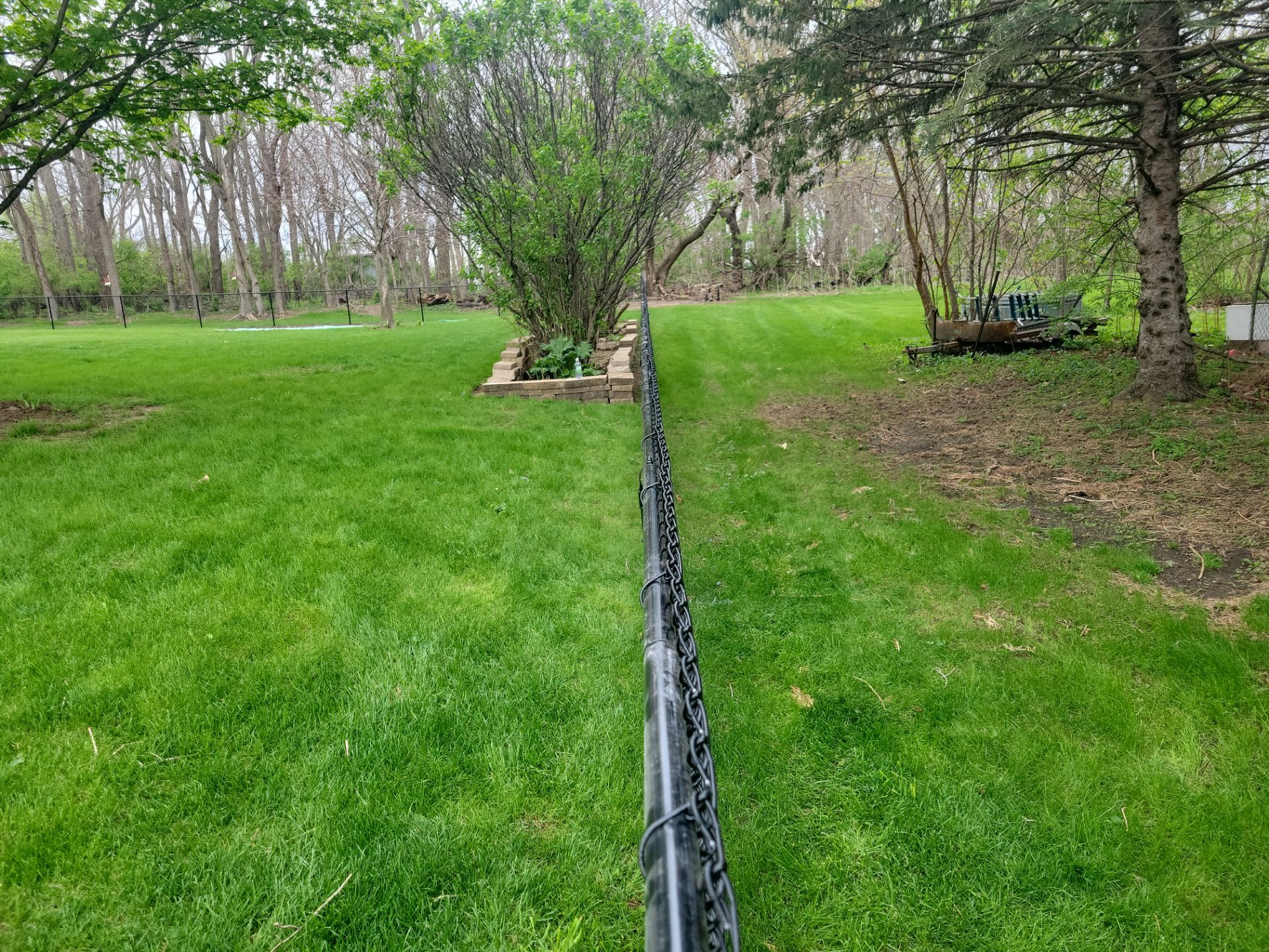 Residential Black Vinyl-Coated Chain Link Perimeter Fence in Garwin by Perfect Picket Fence and Stain