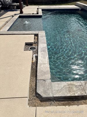 Modern Geometric Pool with Raised Stone Wall and Paver Deck
