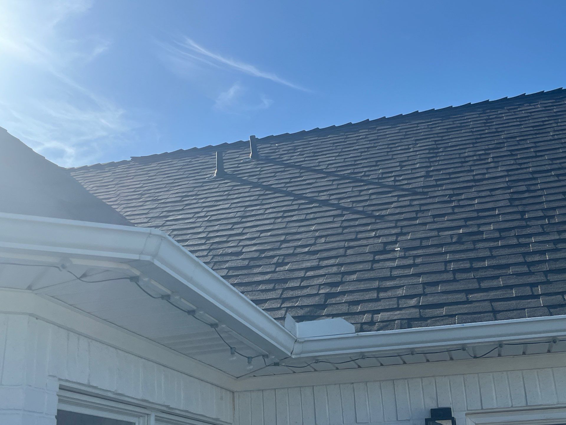 White brick with Malarkey Brilliant Black by Tejas Roofworks + Restoration