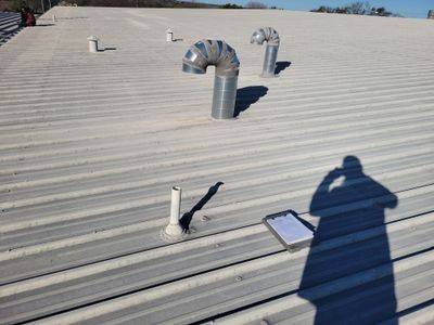 Wide view of metal roof with multiple vent stacks