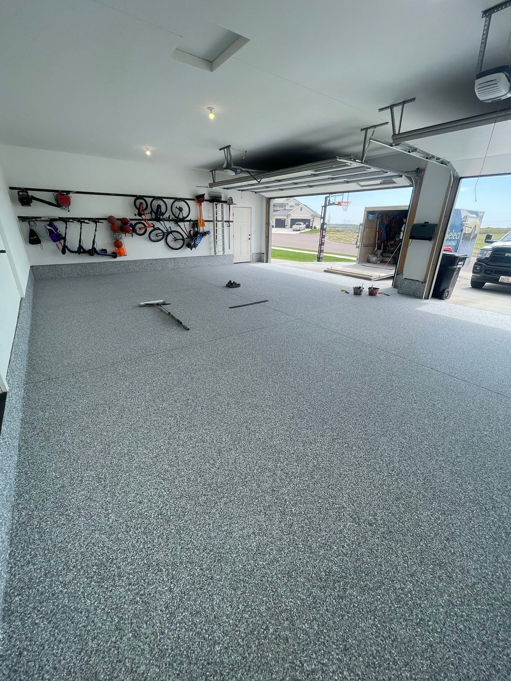 Full Garage Concrete Coating with Grey Speckled Epoxy in Brandon by Select Painting, Coatings & Garage Cabinets