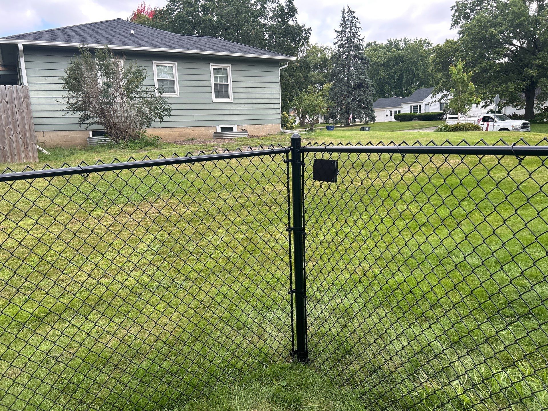 Black Vinyl Coated Chain Link Fence Installation in Waterloo by Perfect Picket Fence and Stain