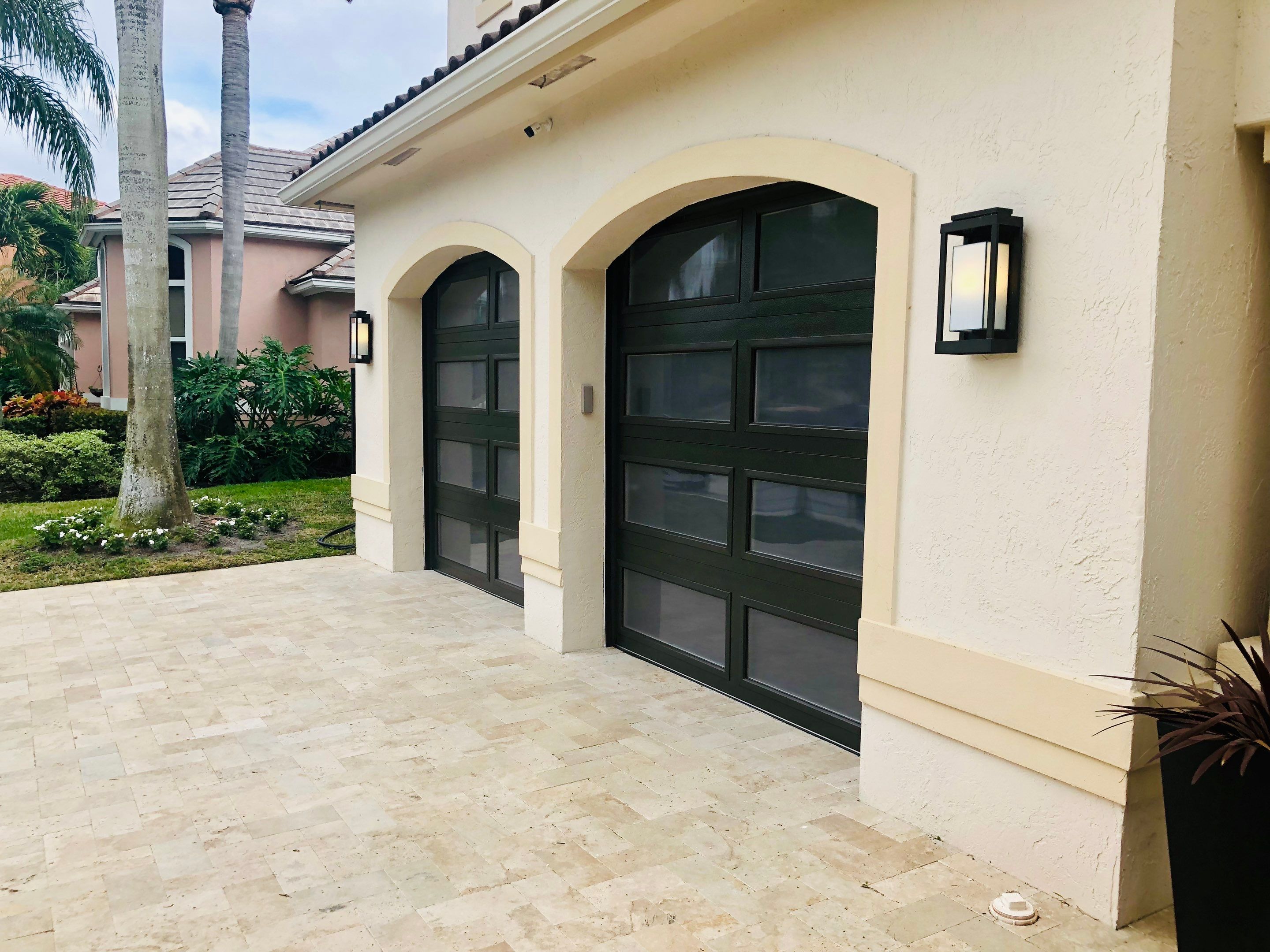 Modern Bronze Garage Door Installation With Frosted Glass in Boca Raton by The Door Doctor of South Florida, Inc.