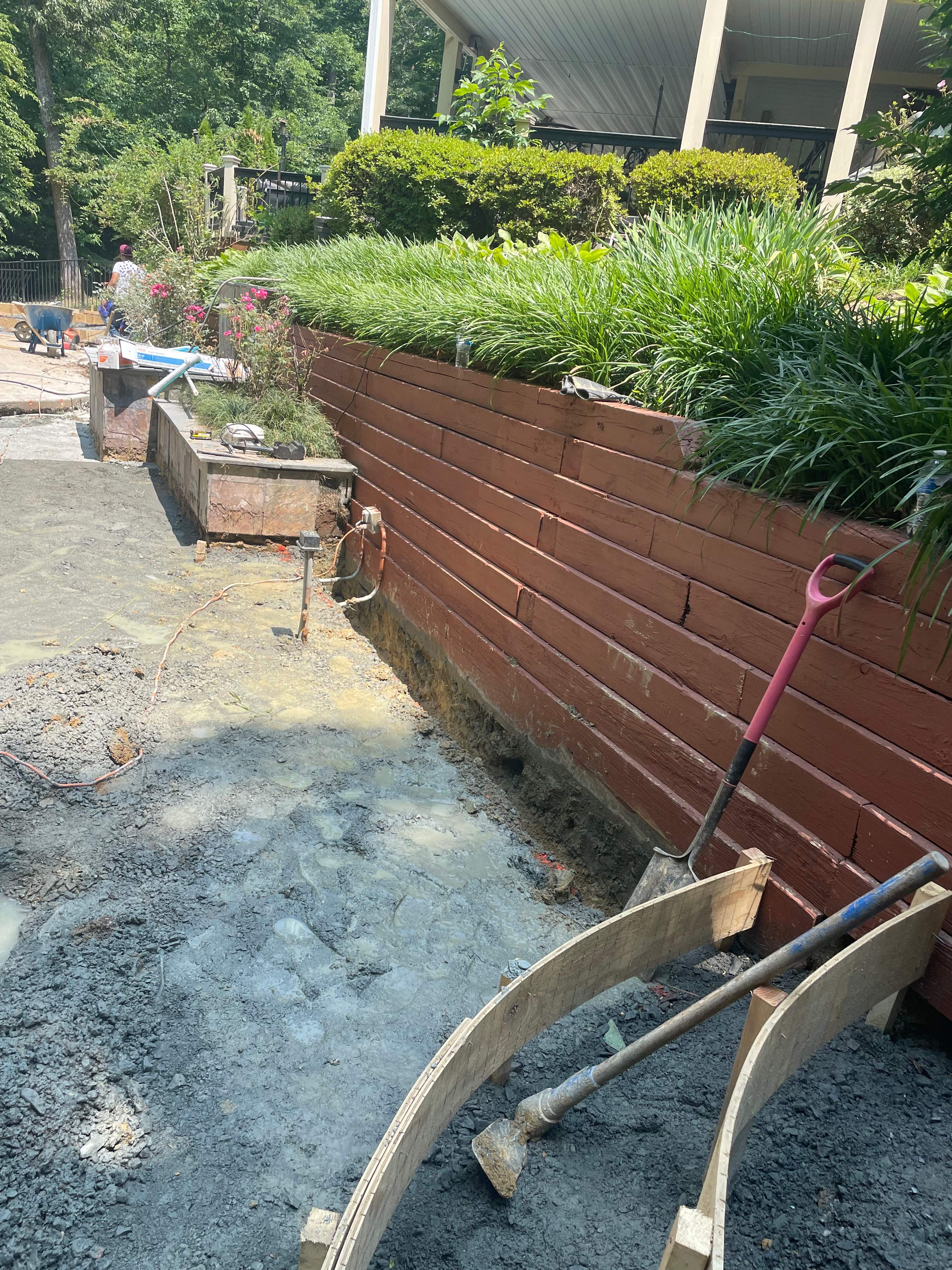 Pool Surround remodel with retaining walls, new waterfall and water slide by Fairfax Contractors, LLC