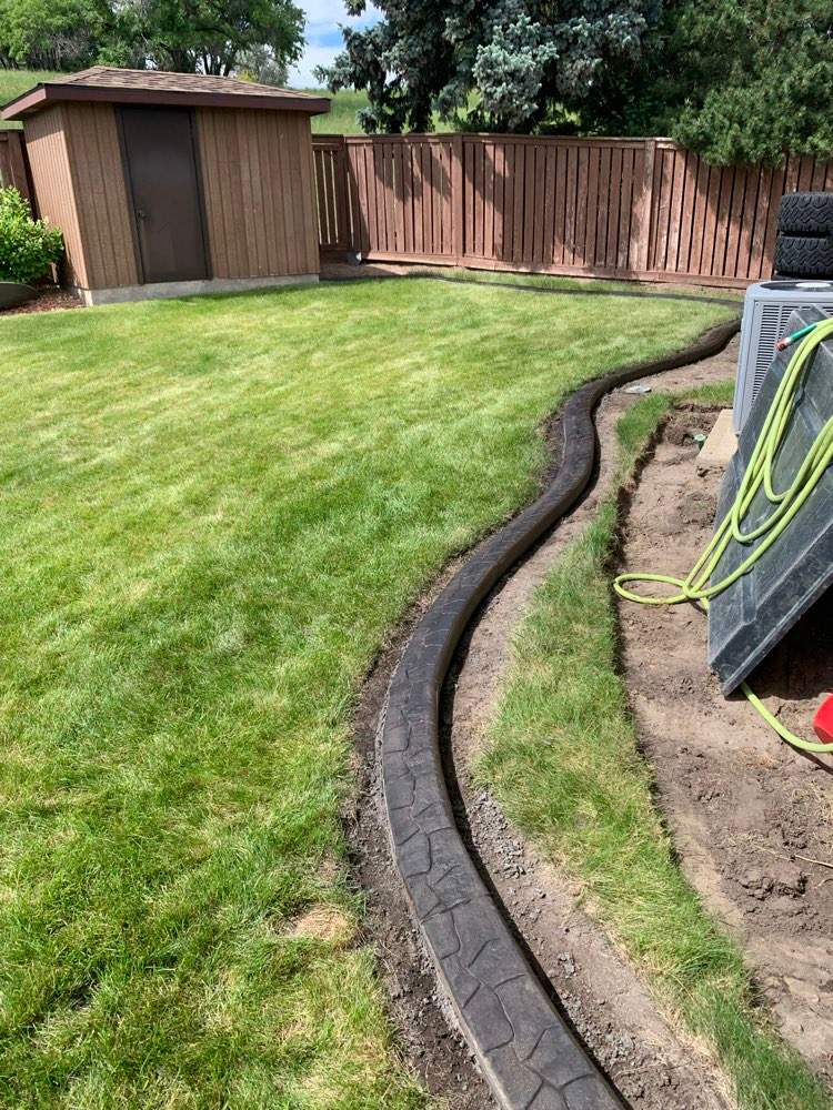 Decorative Stamped Concrete Garden Border Installation in Medicine Hat by Pump it Up Concrete Jacking