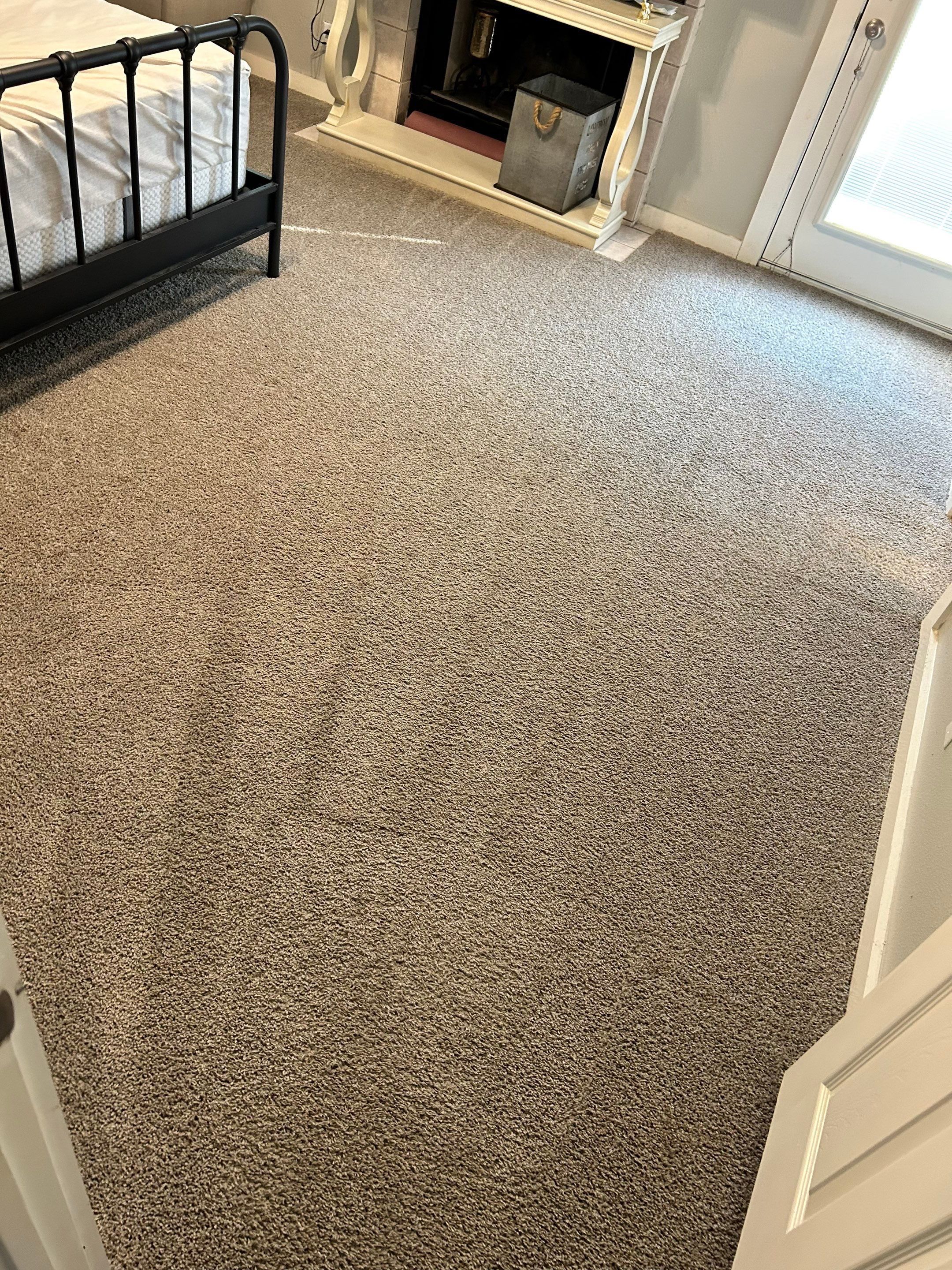 carpet cleaning service in a bedroom with a bed and fireplace