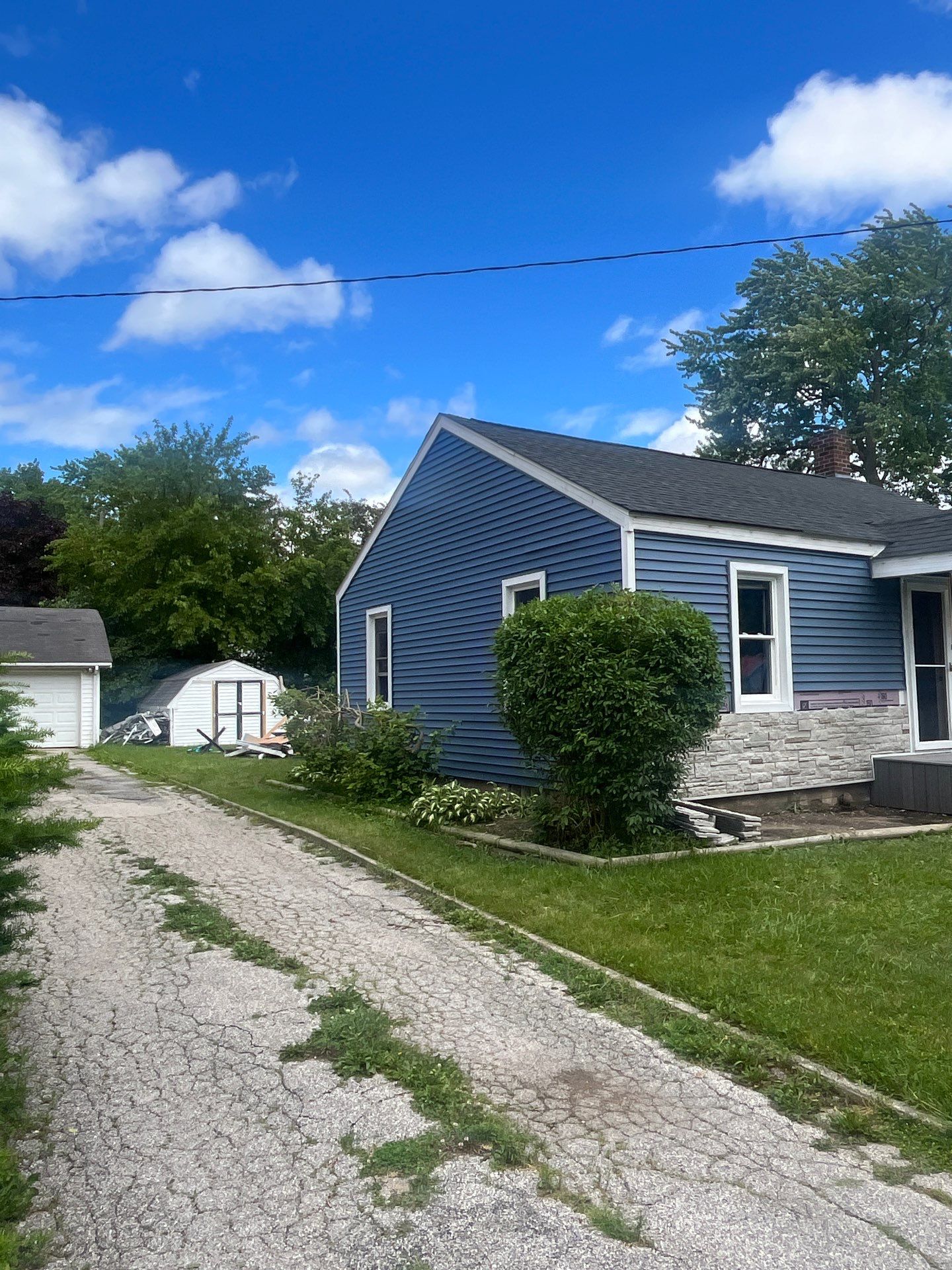 Blue Vinyl Siding and Versetta Stone Exterior Remodel in Bay City by Great Lakes Home Design LLC