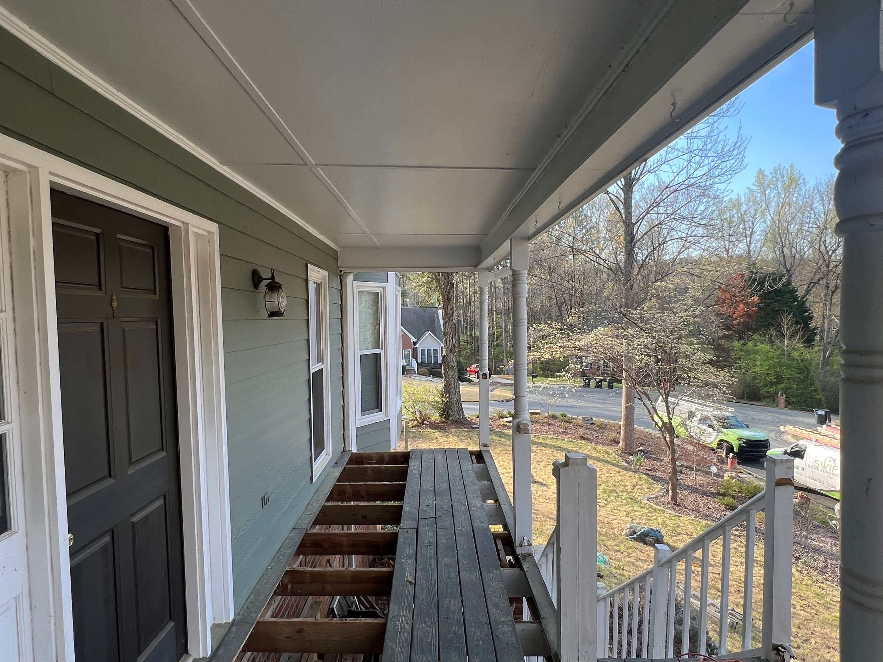 Composite Deck and Porch Renovation With Black Metal Railings by Swift Home Renovations 