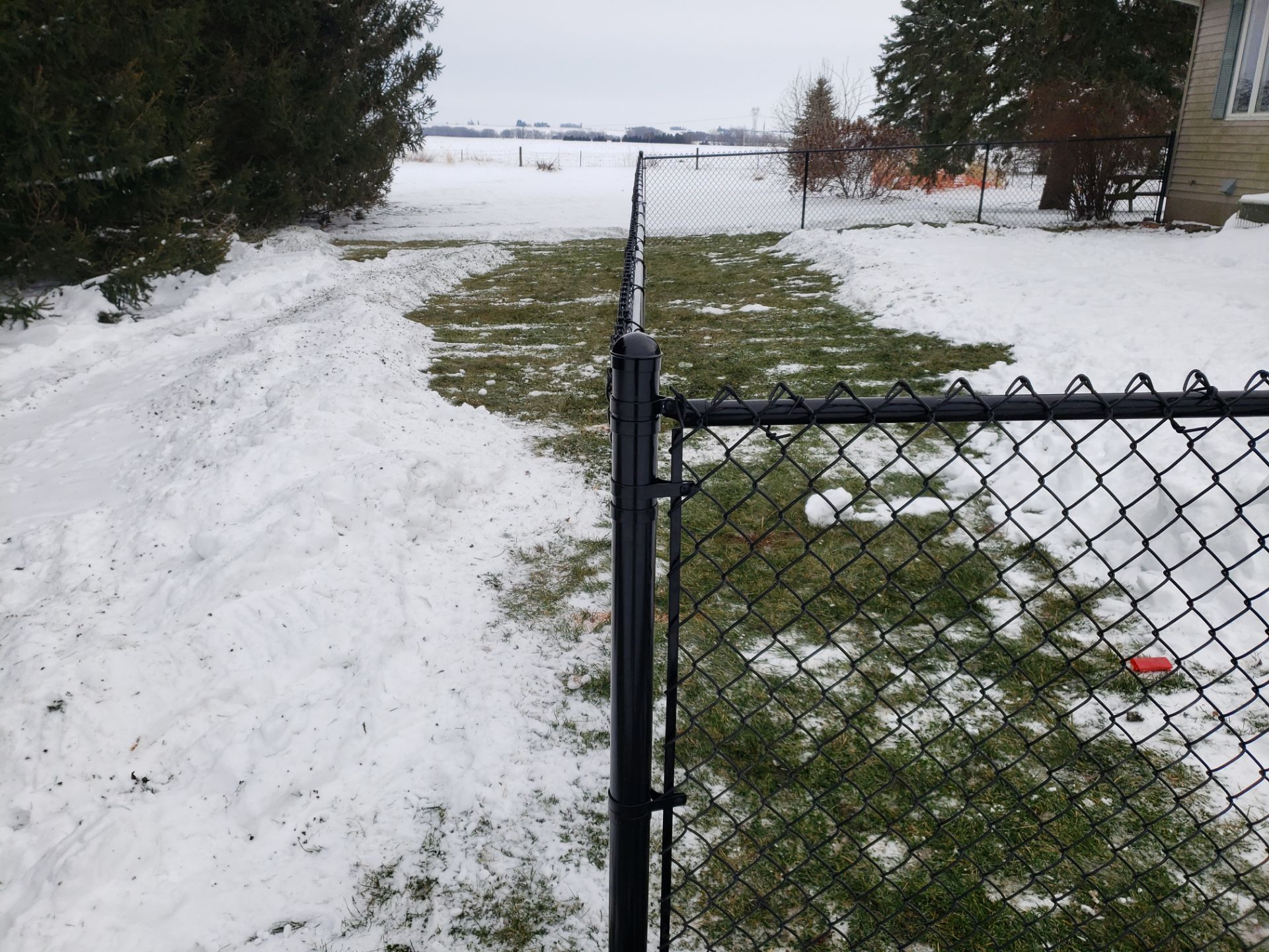Black Vinyl-Coated Chain Link Fence Installation in Oelwein by Perfect Picket Fence and Stain