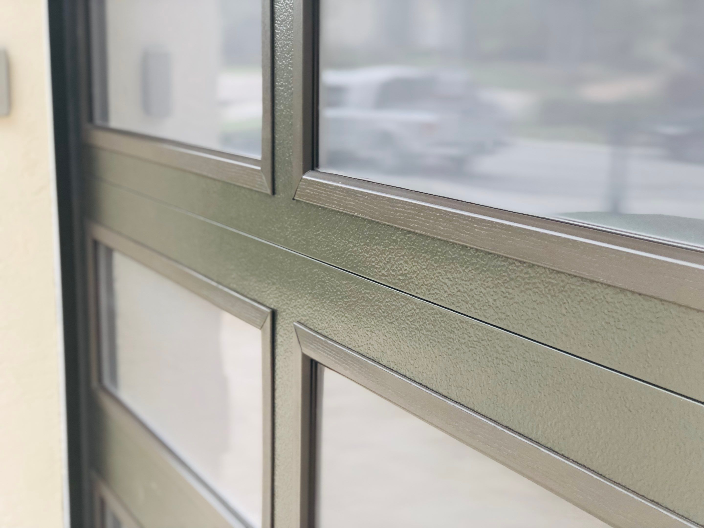 Modern Bronze Garage Door Installation With Frosted Glass in Boca Raton by The Door Doctor of South Florida, Inc.