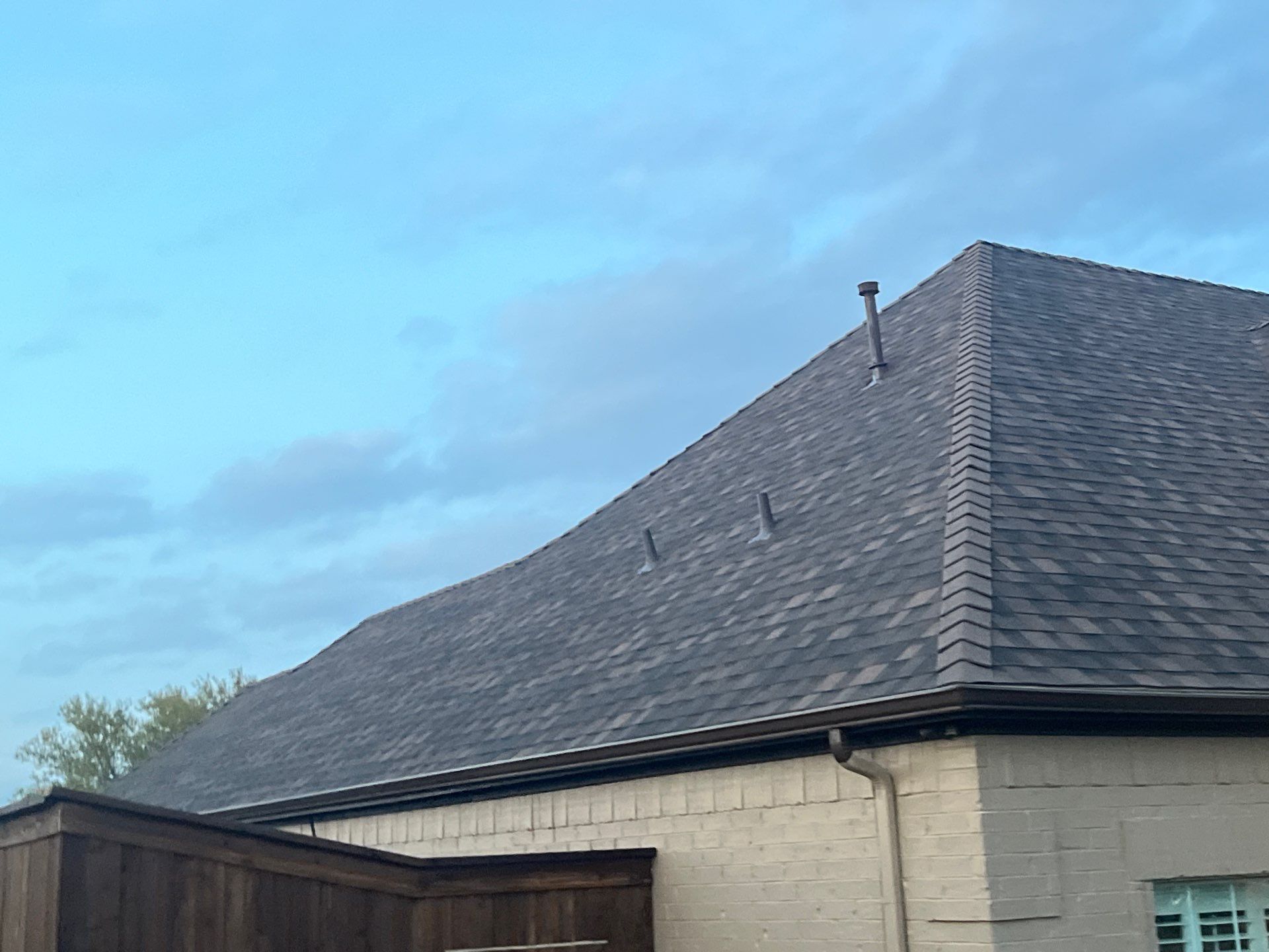 Cream brick/mixed stone with IKO Shadow Brown by Tejas Roofworks + Restoration