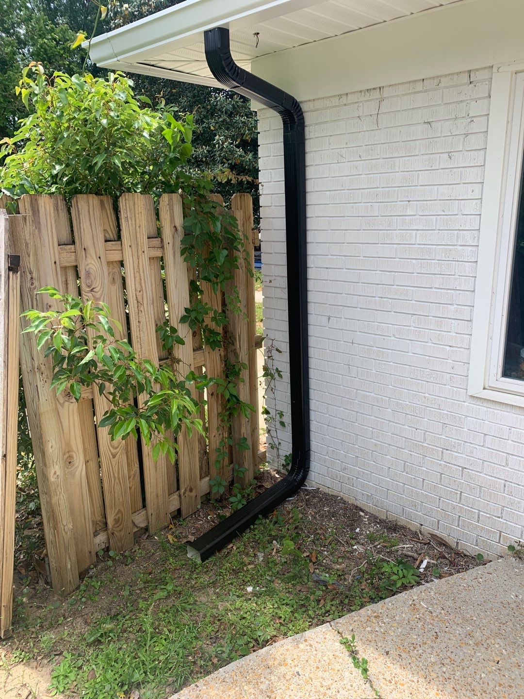 White Seamless Gutters and Black Downspouts by Gutter Professors