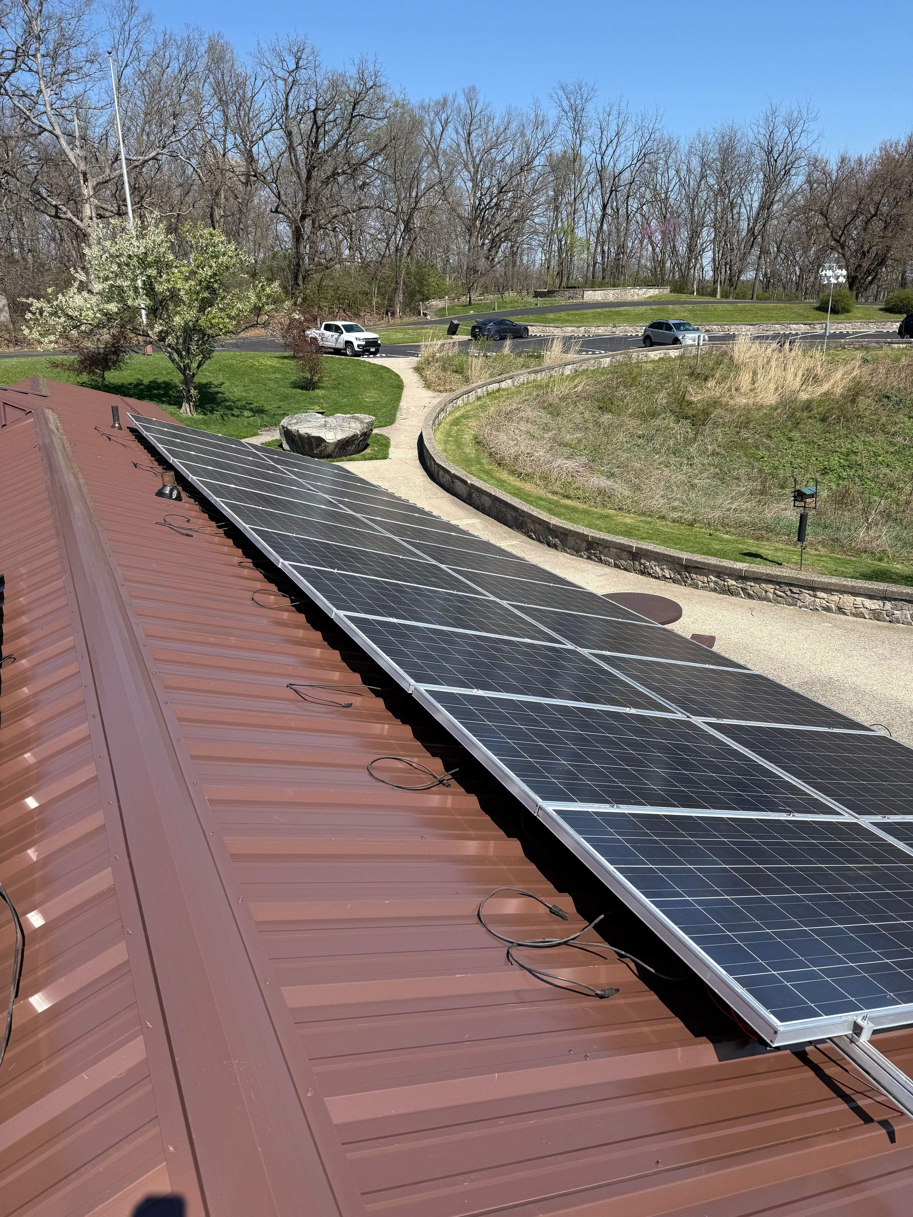 Brown R-Panel metal roof with solar by Atlas Roofing & Restoration