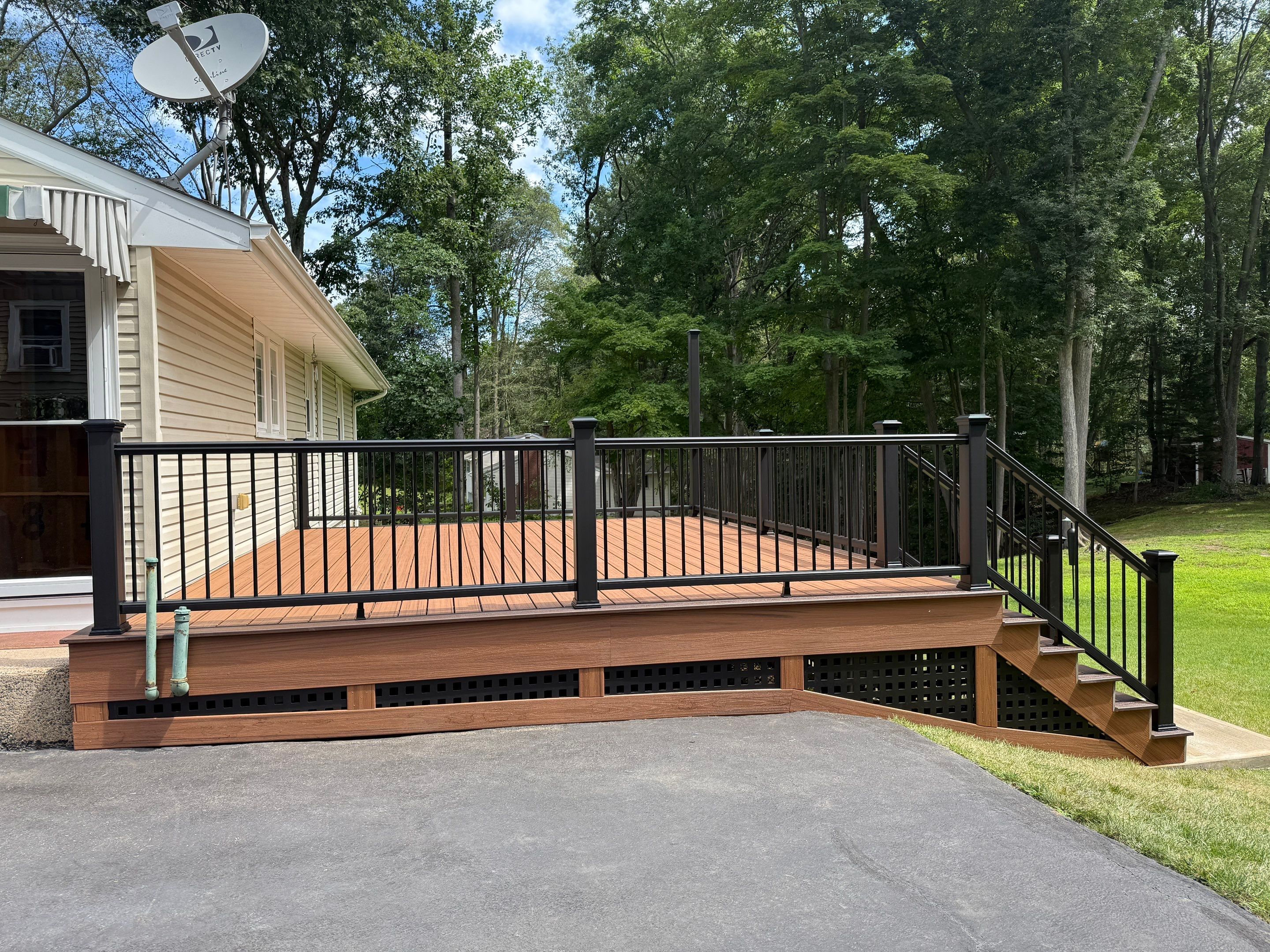 Replacement Deck, Trex Tropical Tiki torch , Matching Fascia. Black Transcend railing and Lattice. by DiGiorgi Roofing and Siding Inc